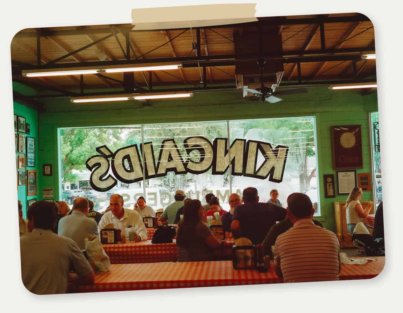 The dining room with the Kincaid's window sign and a vintage airplane at Kincaid's Hamburgers in Fort Worth