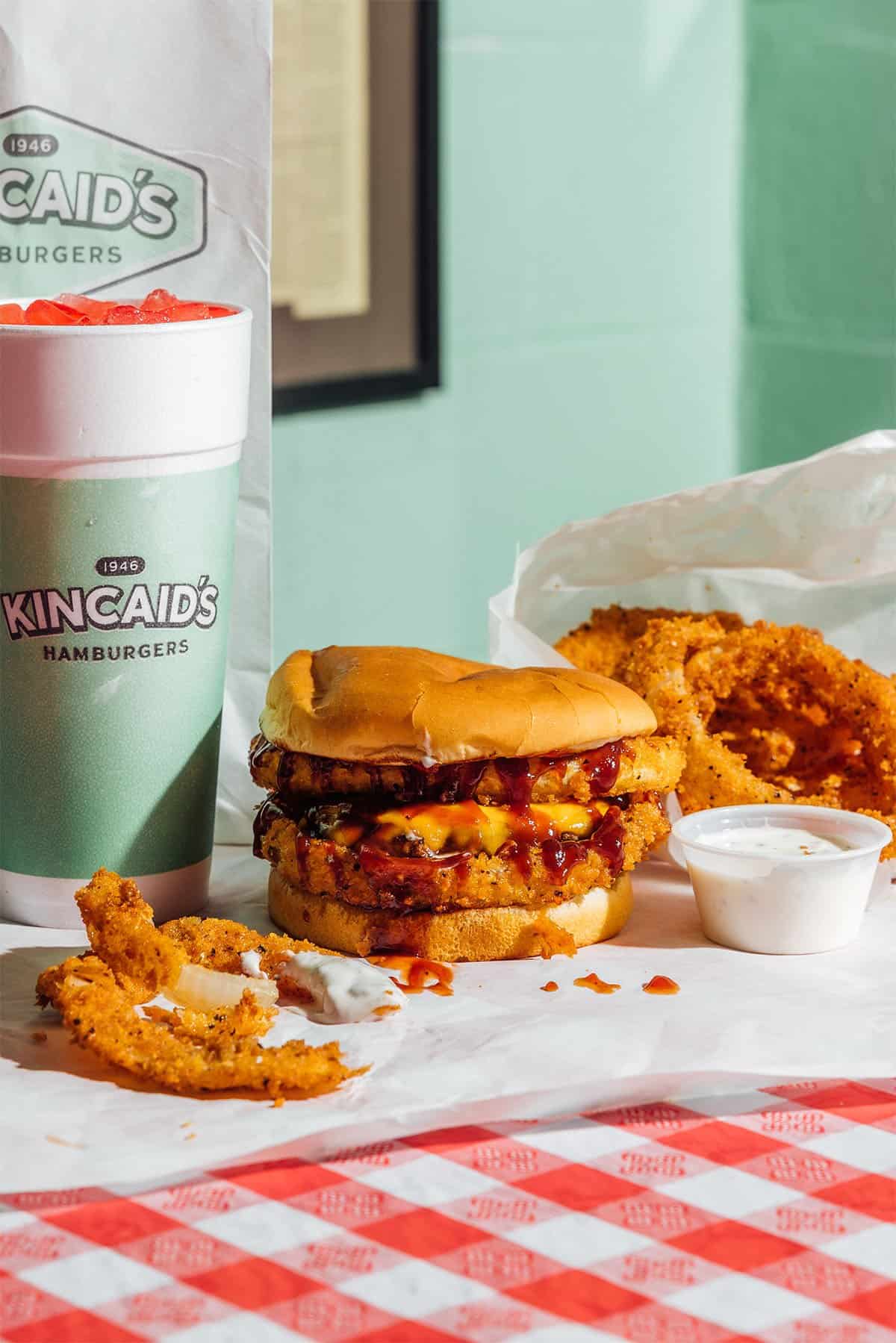 A crispy fried chicken sandwich with a drink at Kincaid's Hamburgers in Fort Worth