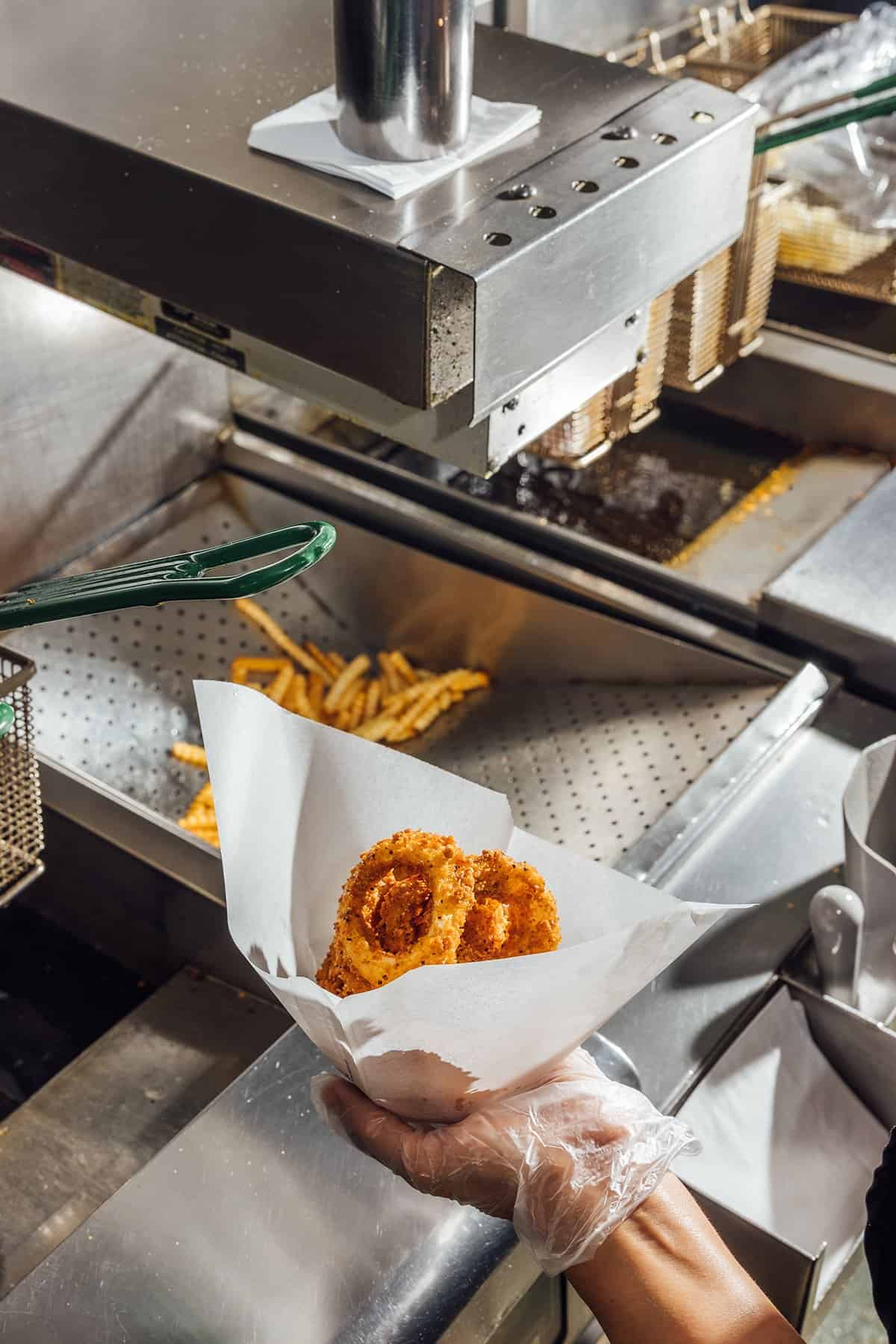 Onion rings and crinkle-cut fries in a paper tray at Kincaid's Hamburgers in Fort Worth