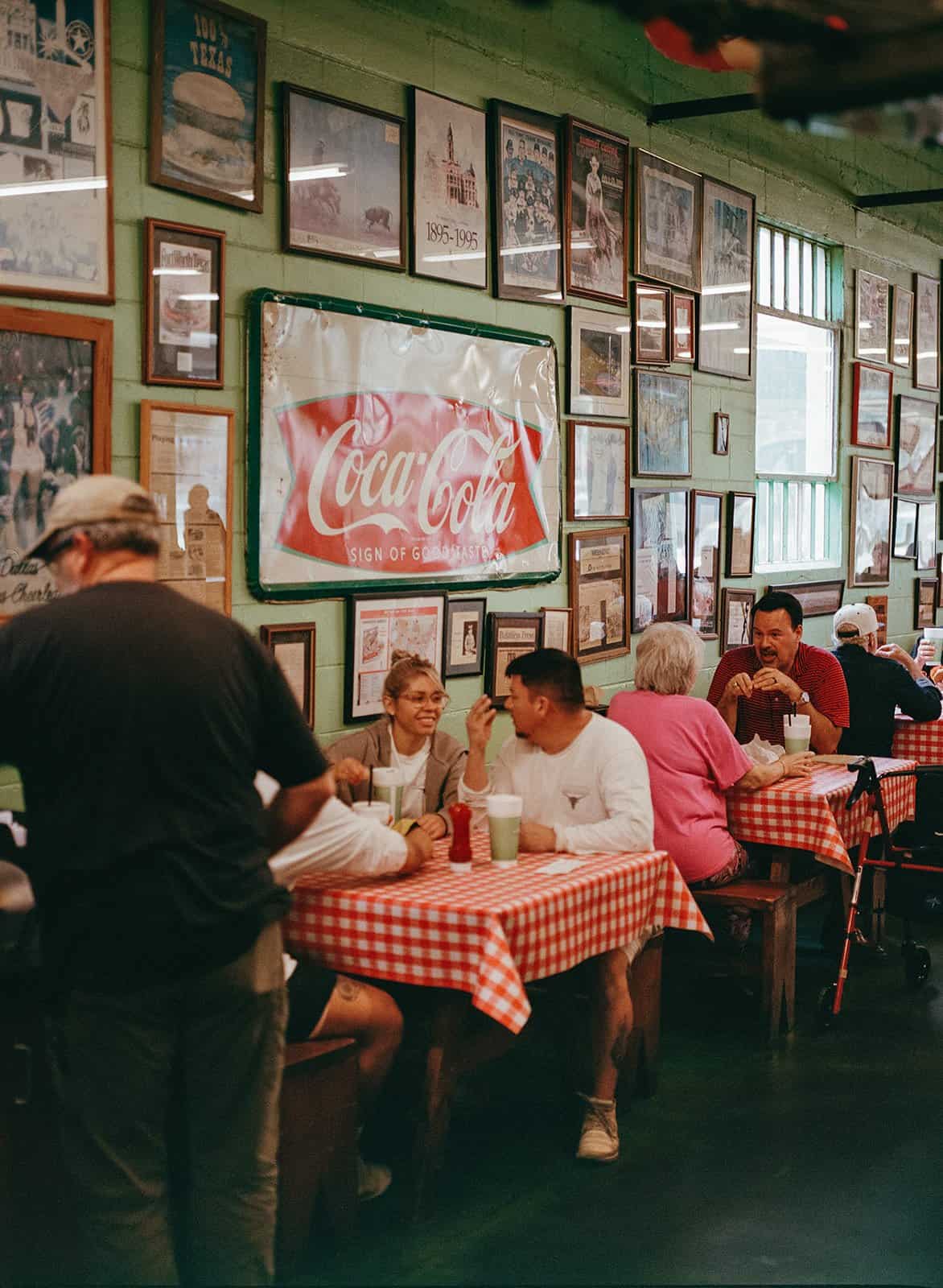 The vintage dining room with framed photos and old signs at Kincaid's Hamburgers in Fort Worth