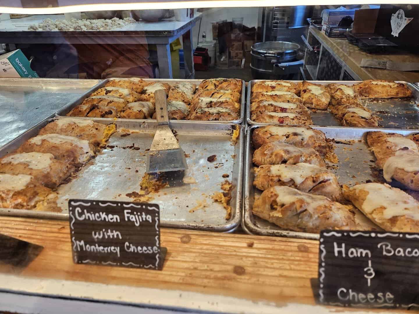 Trays of freshly baked sausage klobasniky at The Original Kolache Shoppe in Houston