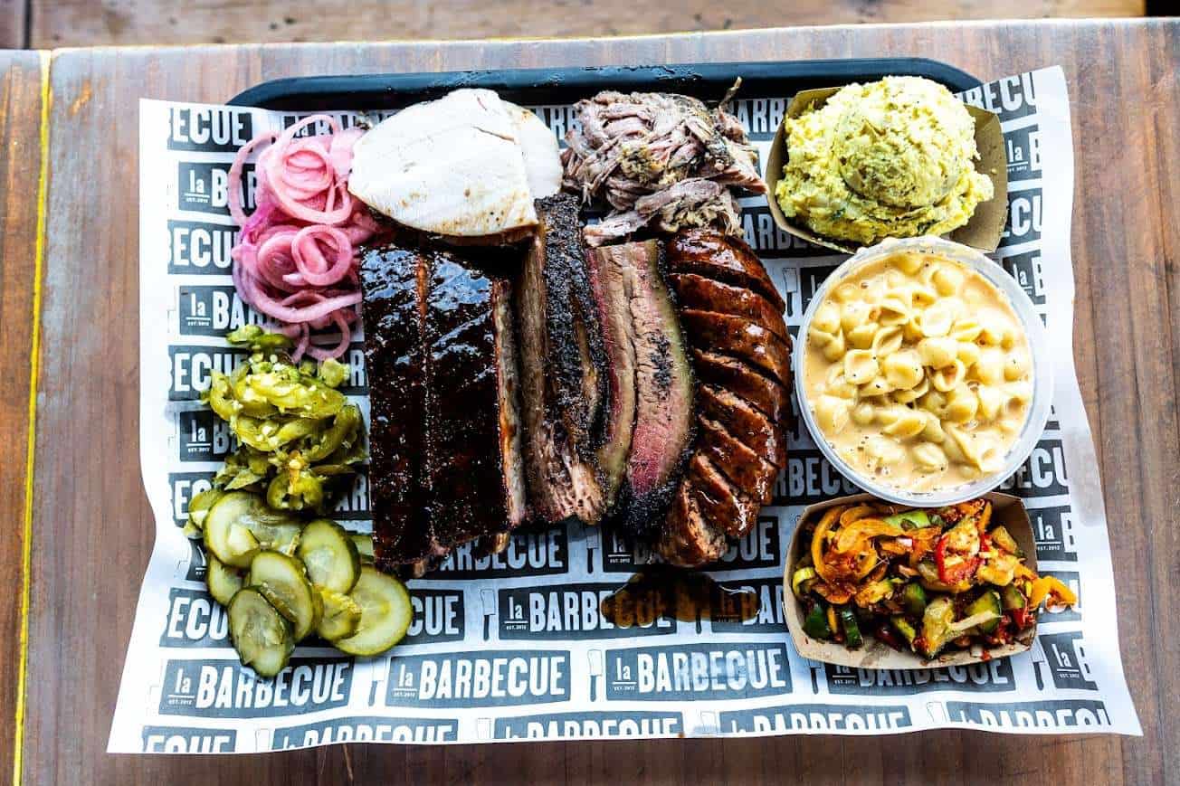Full tray of brisket and sides on branded butcher paper at la Barbecue in Austin, Texas