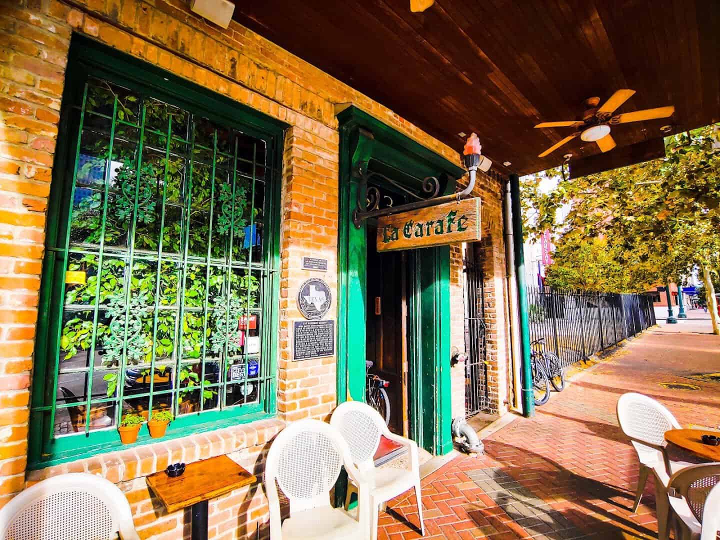 Corner of the historic La Carafe building with green stained glass windows in Houston