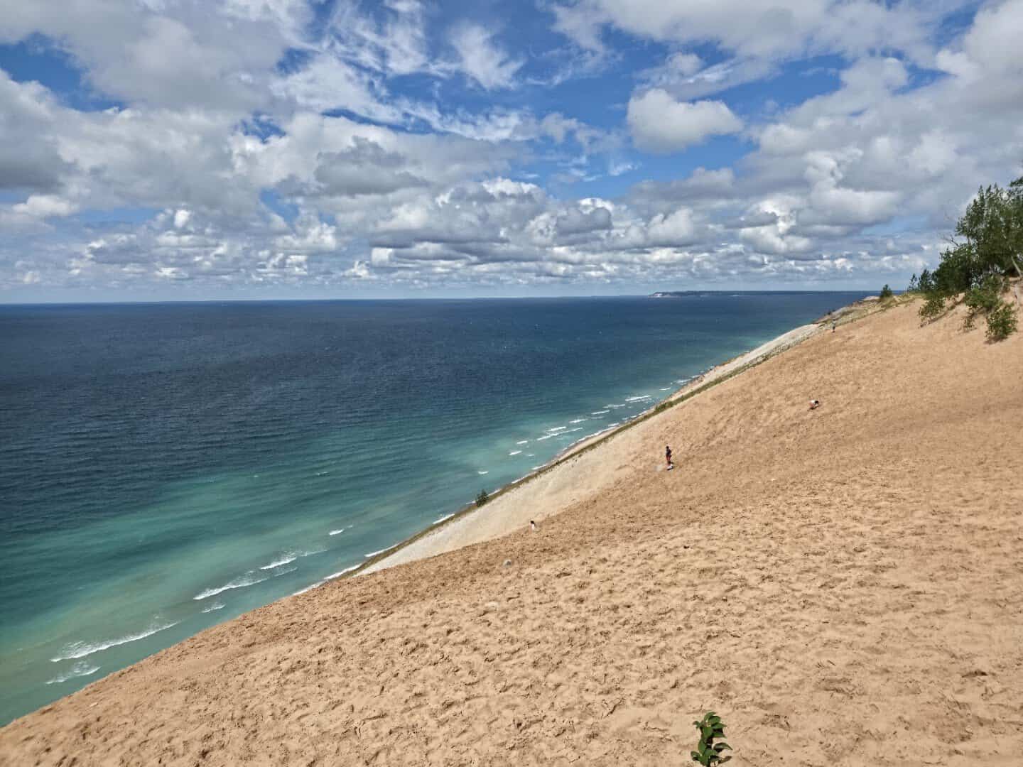 Sand dune dropping to the blue water of Lake Michigan at the Lake Michigan Overlook, Michigan