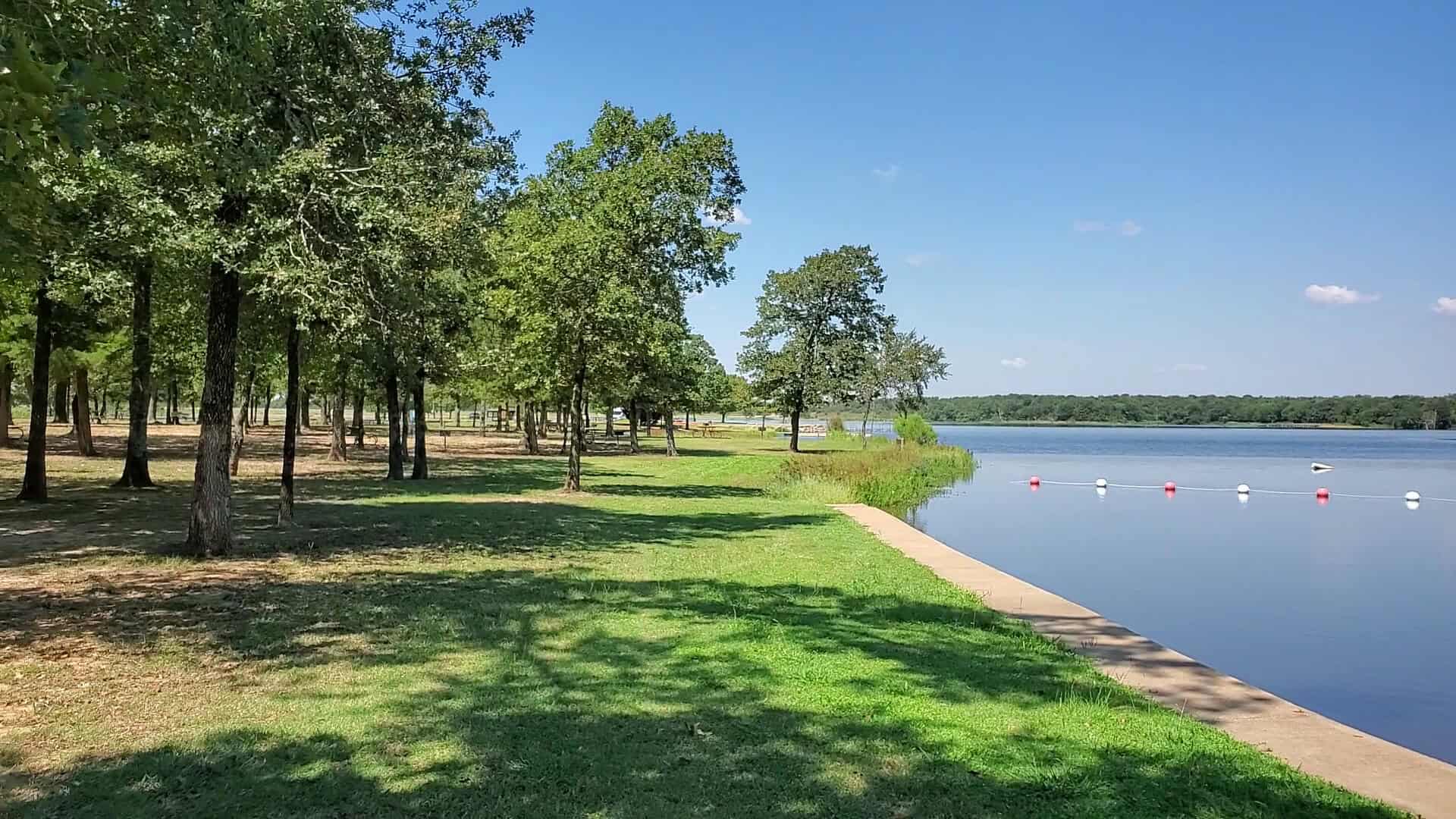 Grassy lakeside campground area at Purtis Creek State Park