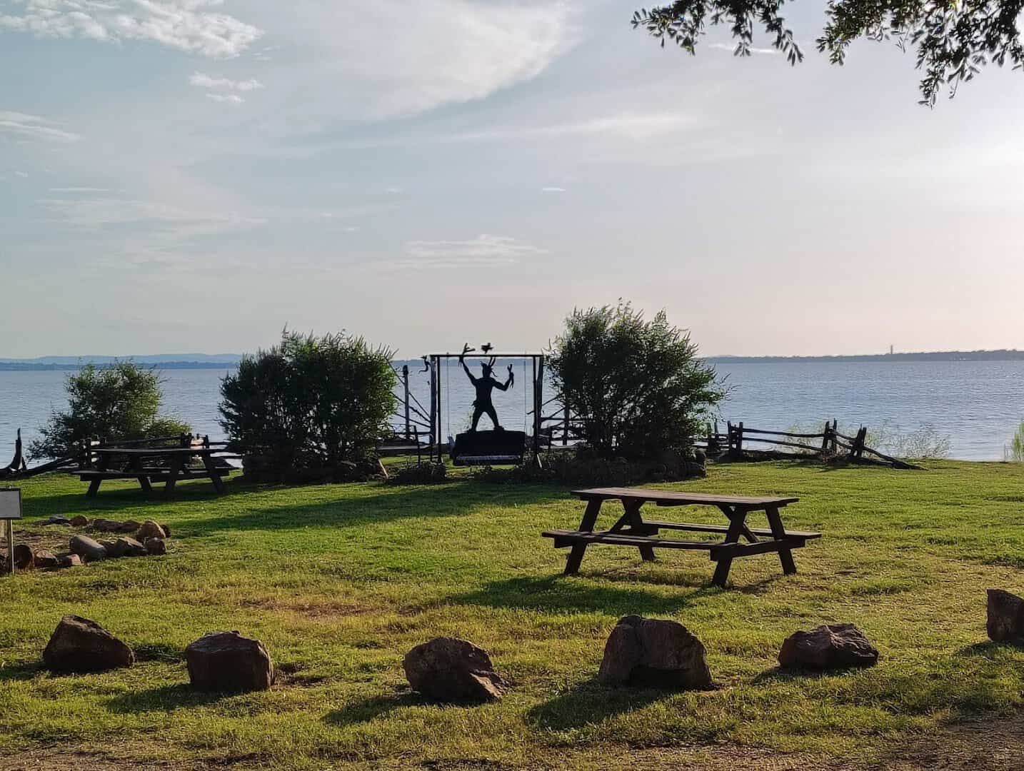 Grassy lakeside grounds with a picnic table at Lake Buchanan RV and Cabin Resort in Burnet, Texas
