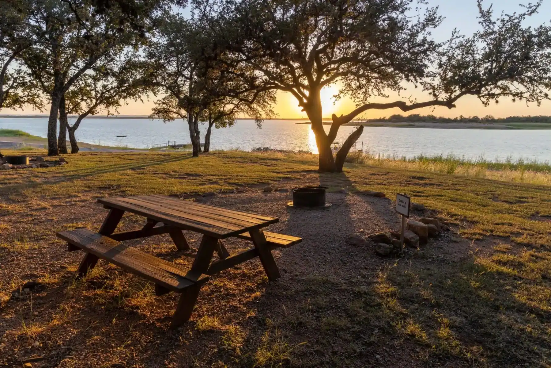 Lakeside picnic table and fire pit at sunset at Lake Buchanan in Burnet, Texas