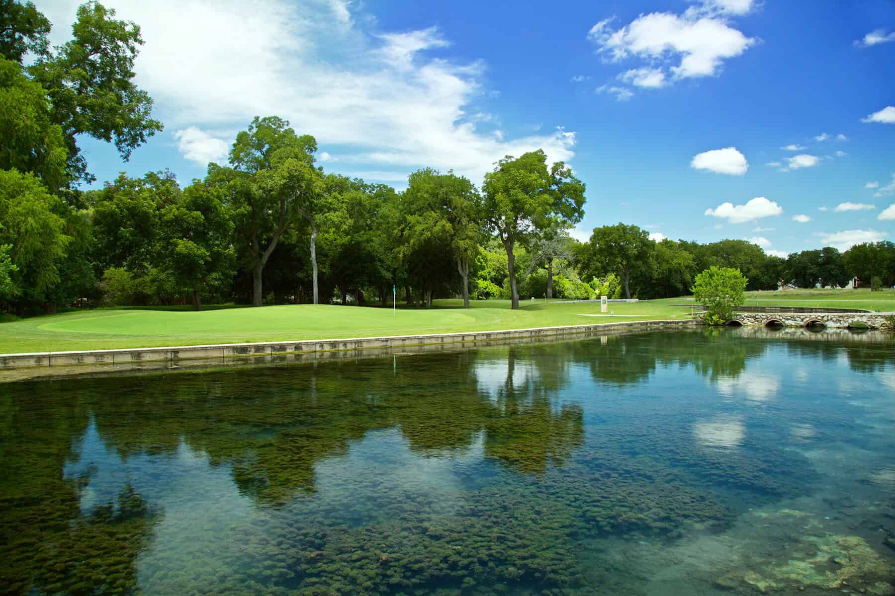 Fairway reflected in the spring water at Landa Park Golf Course at Comal Springs, New Braunfels
