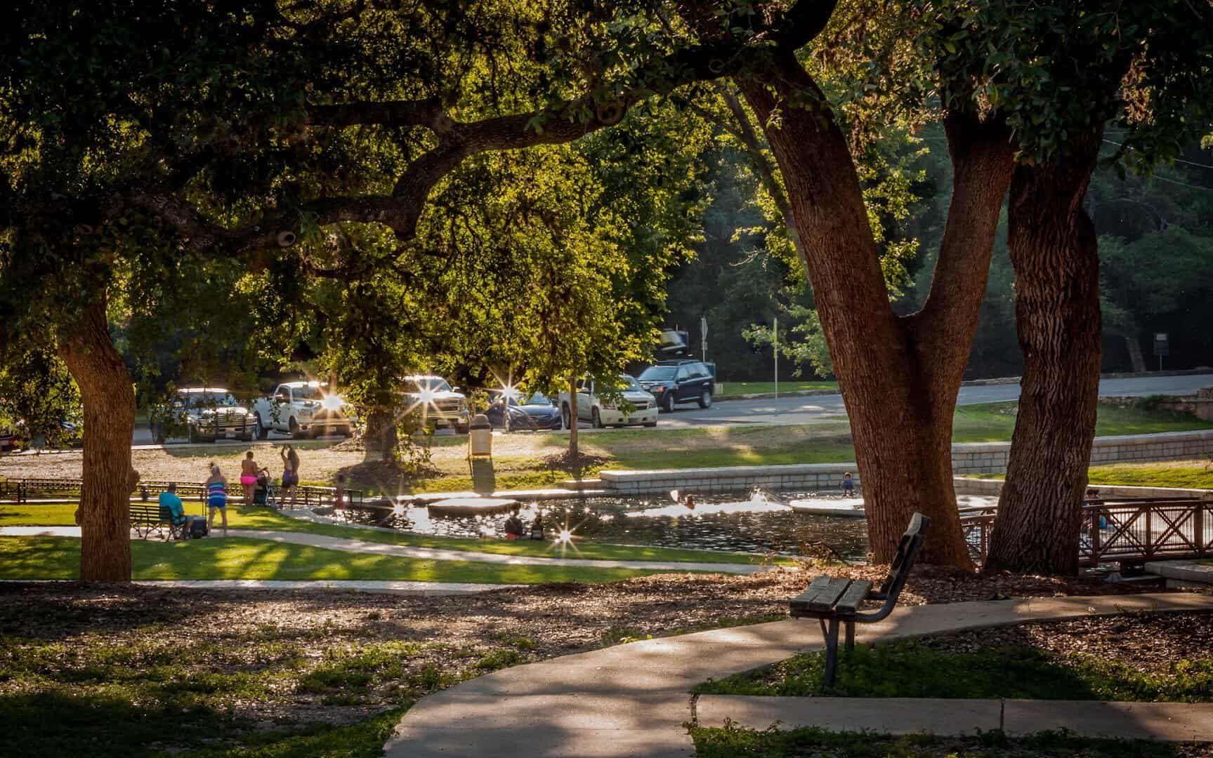 Shaded oaks and picnic area beside the water at Landa Park in New Braunfels, Texas