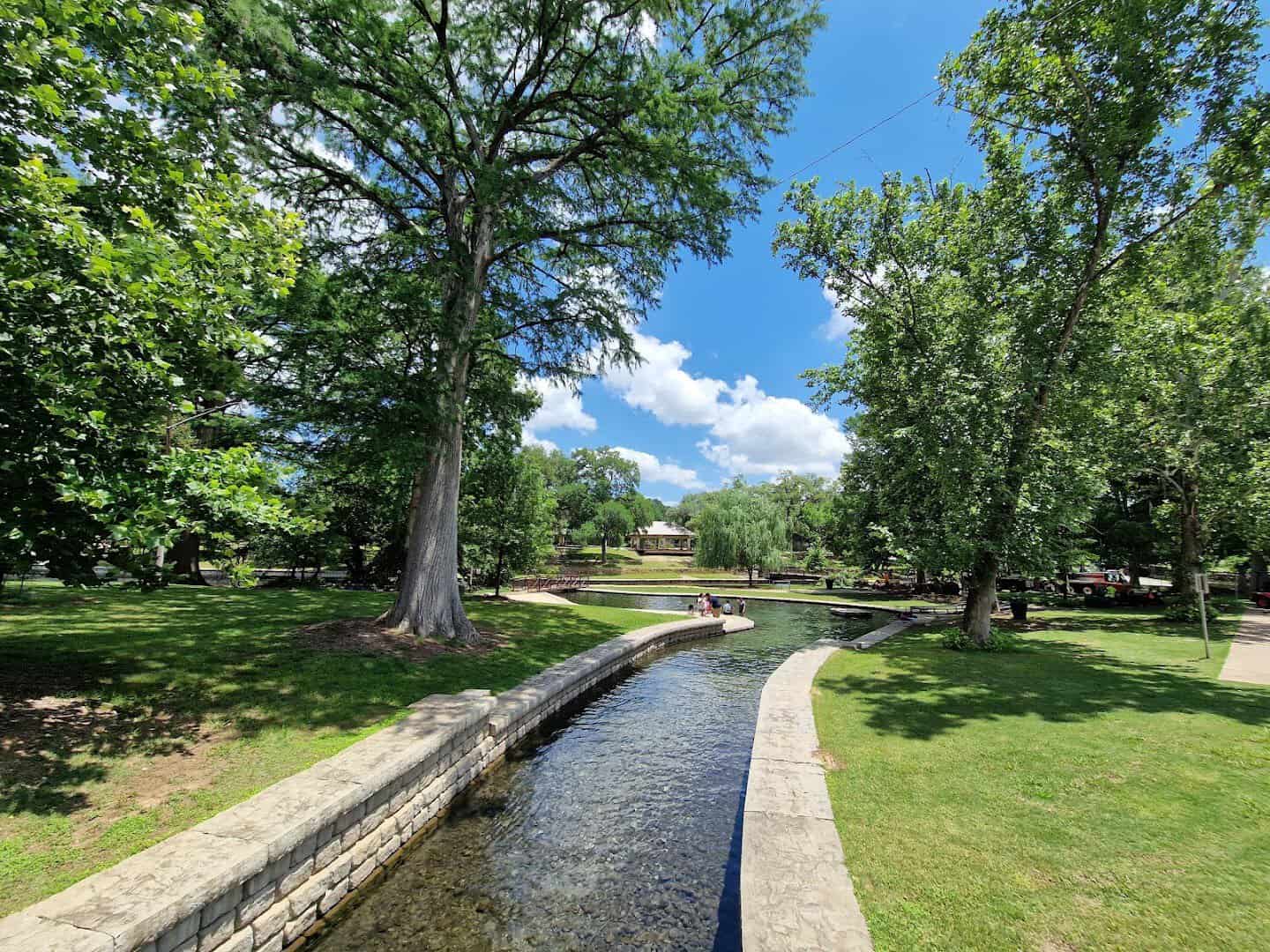 Stone lined channel of the Comal River winding through Landa Park in New Braunfels, Texas