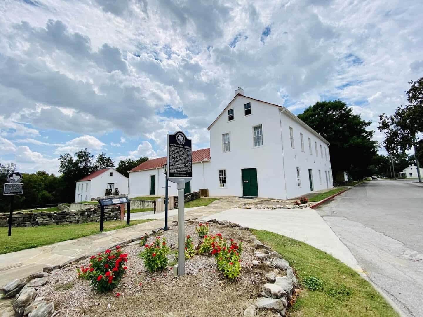 The white two-story Landmark Inn State Historic Site in Castroville, Texas