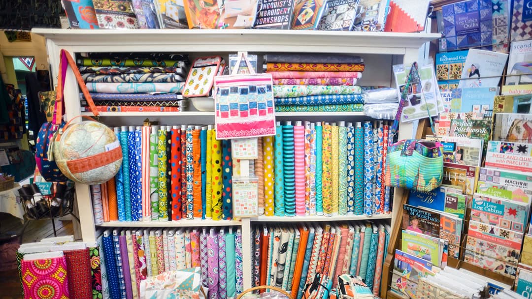 Shelves of colorful quilting fabric bolts at Las Colchas in San Antonio