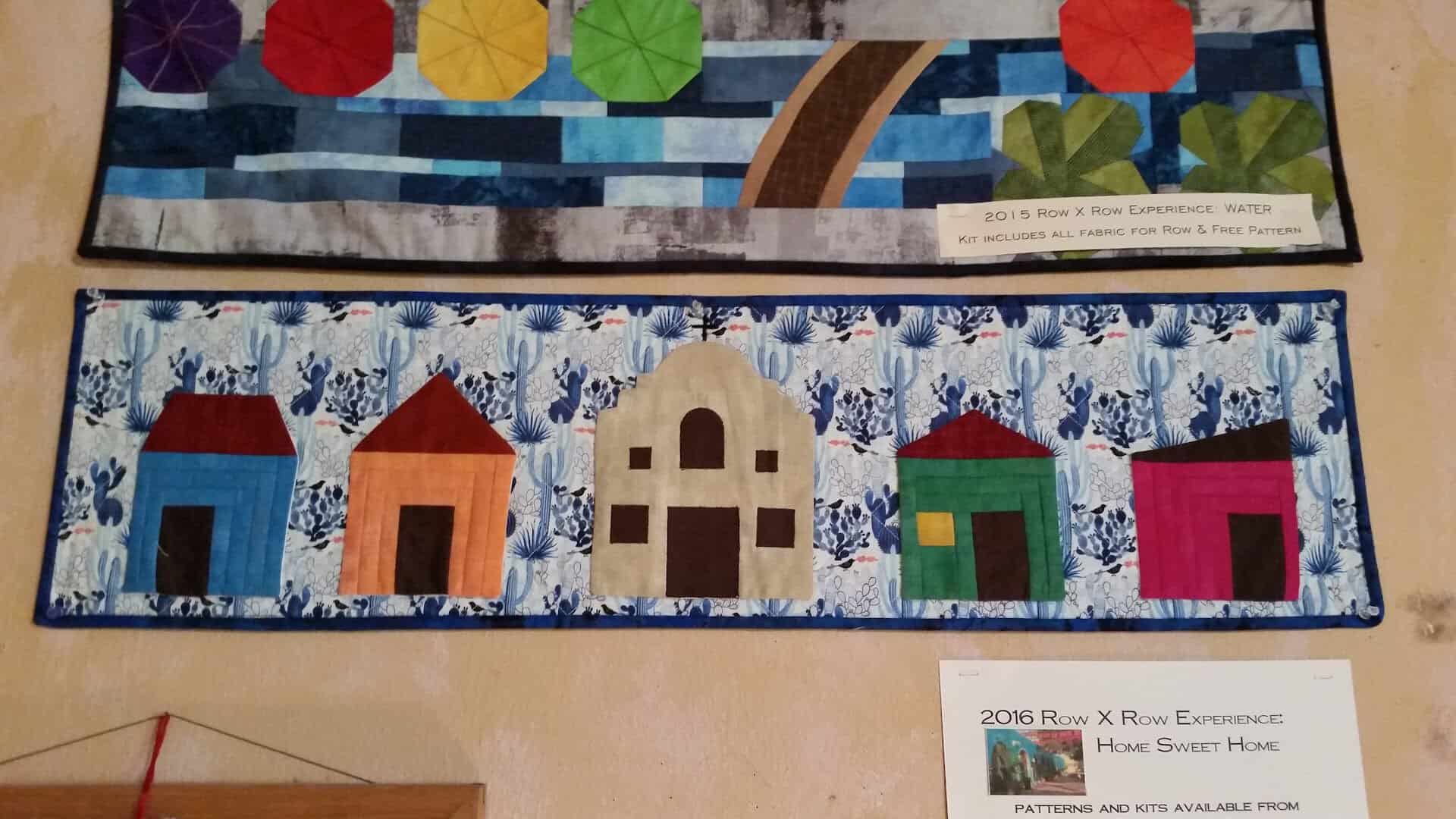 Colorful row-of-houses quilt sample at Las Colchas in San Antonio