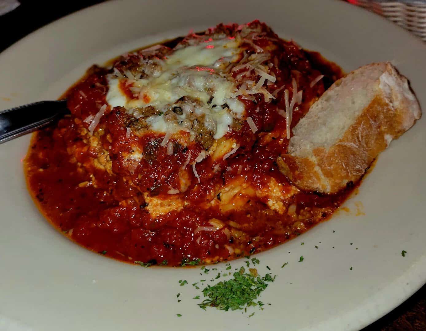 Lasagna in red sauce with bread at Roman Cucina in Dallas