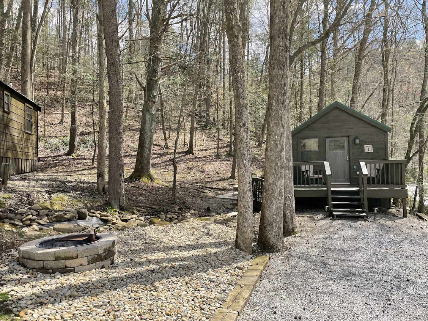 Small cabins among the trees with a fire pit at Little Arrow Outdoor Resort in Townsend, Tennessee