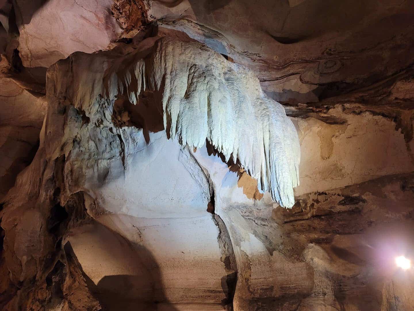 White flowstone and stalactite formations on the ceiling of Longhorn Cavern in Burnet, Texas