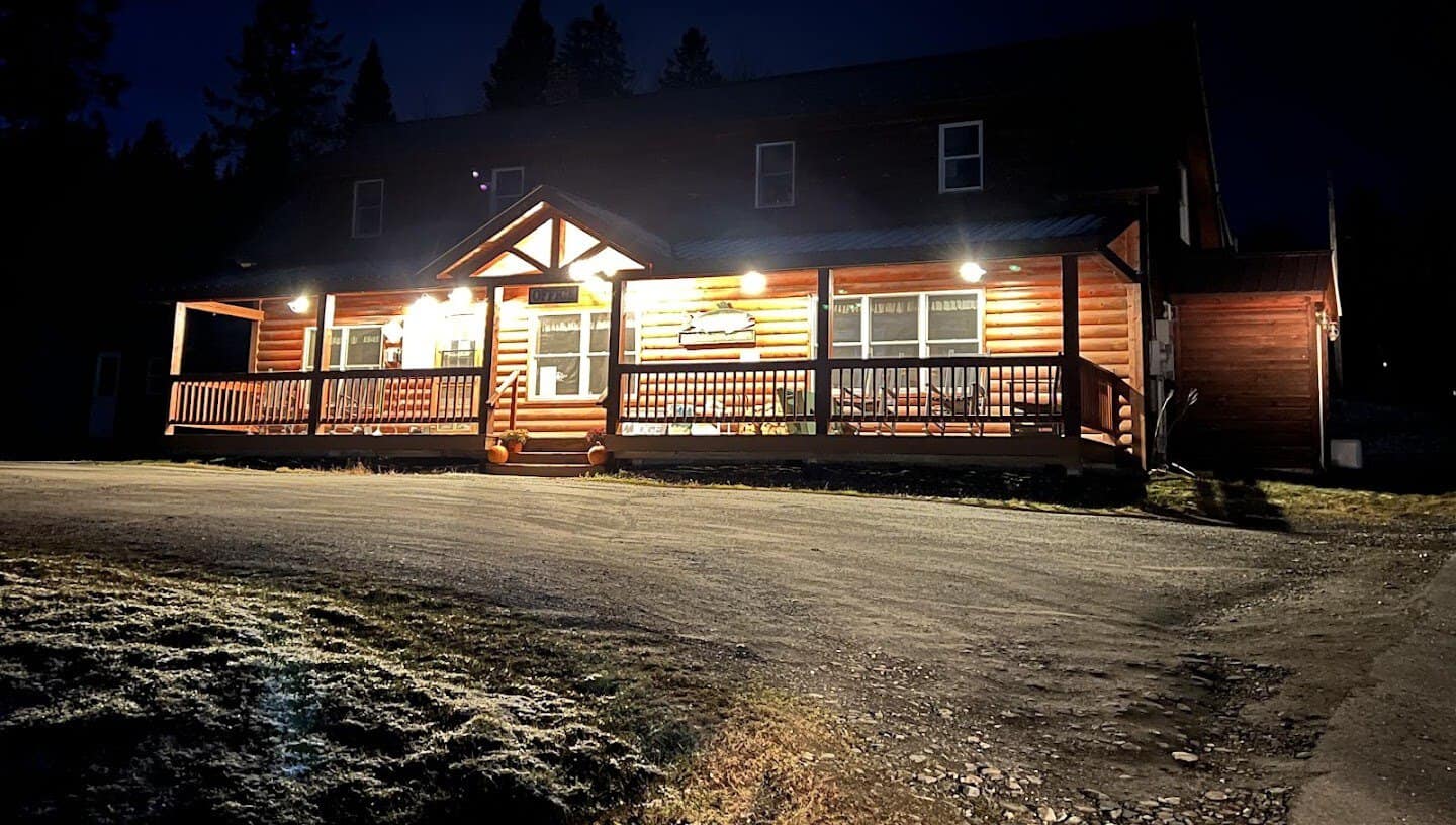 Log cabins lit up at dusk at Lopstick in Pittsburg, New Hampshire