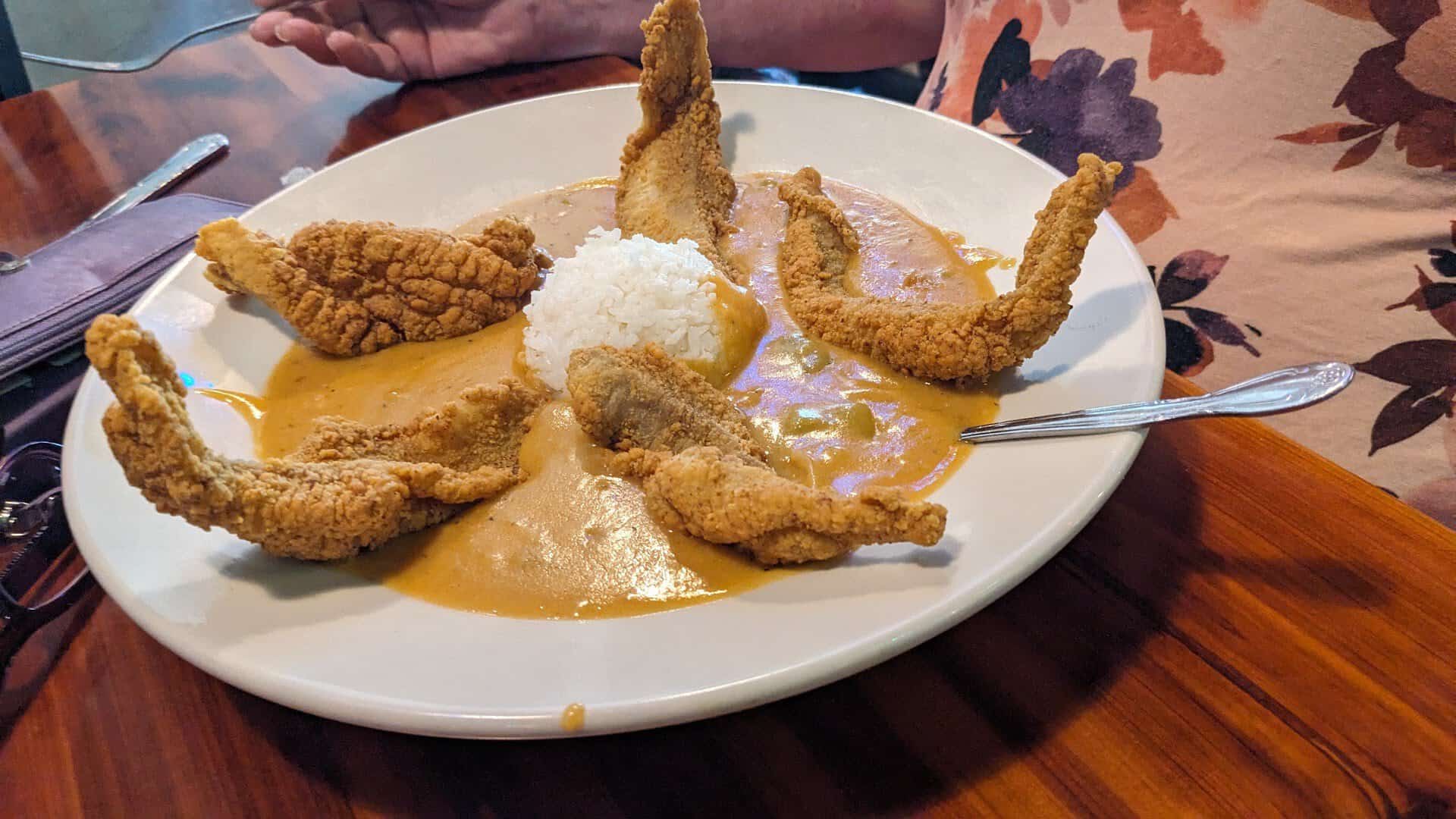 Golden fried frog legs over rice and etouffee at Louisiana Longhorn Cafe in Round Rock, Texas