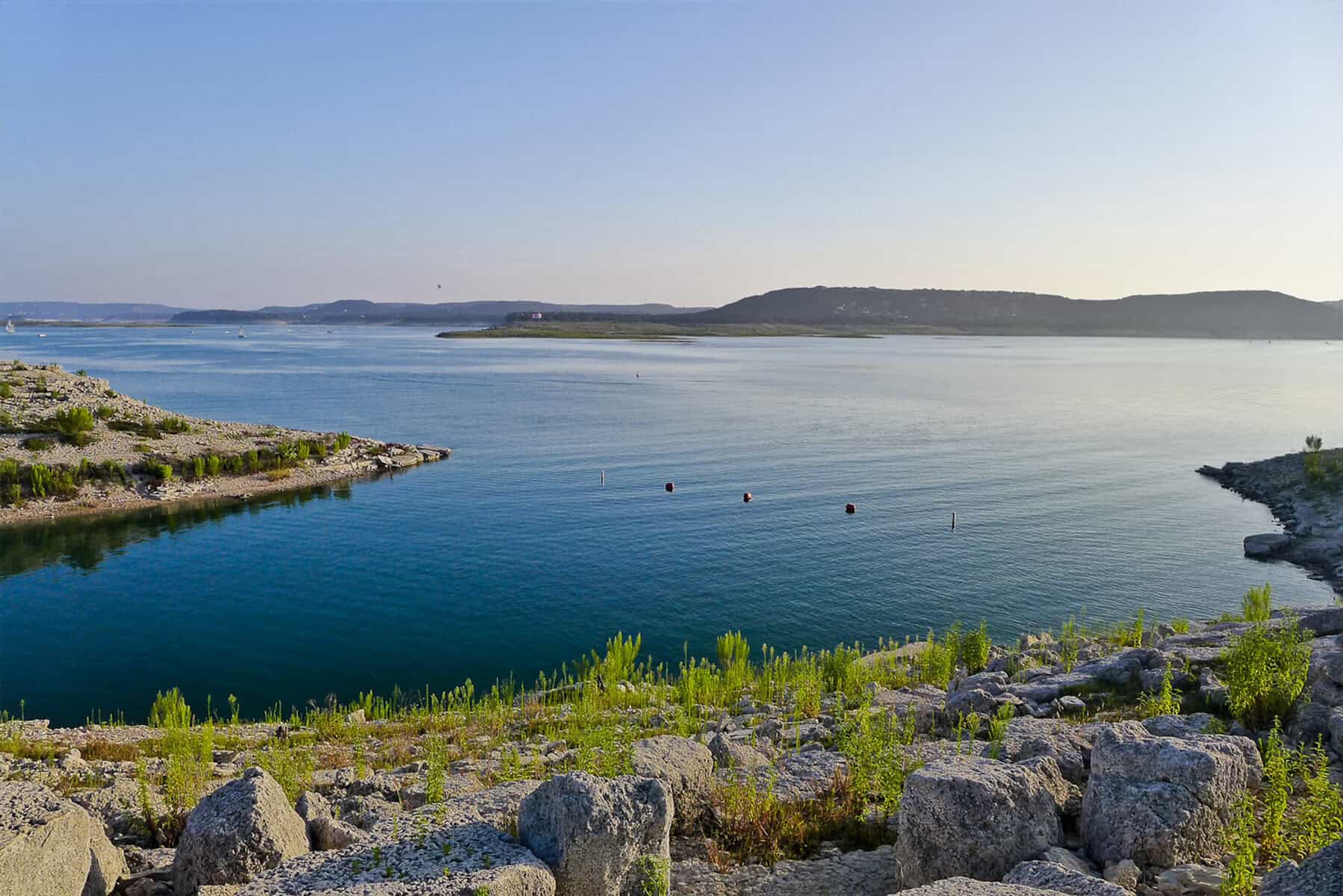 Rocky dive shoreline and deep blue water at Mansfield Dam Park on Lake Travis