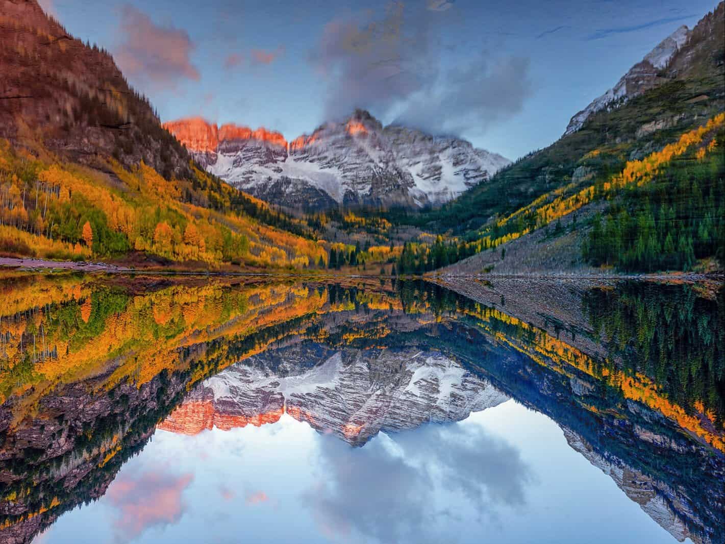 The Maroon Bells reflected in Maroon Lake with golden fall aspens near Aspen, Colorado