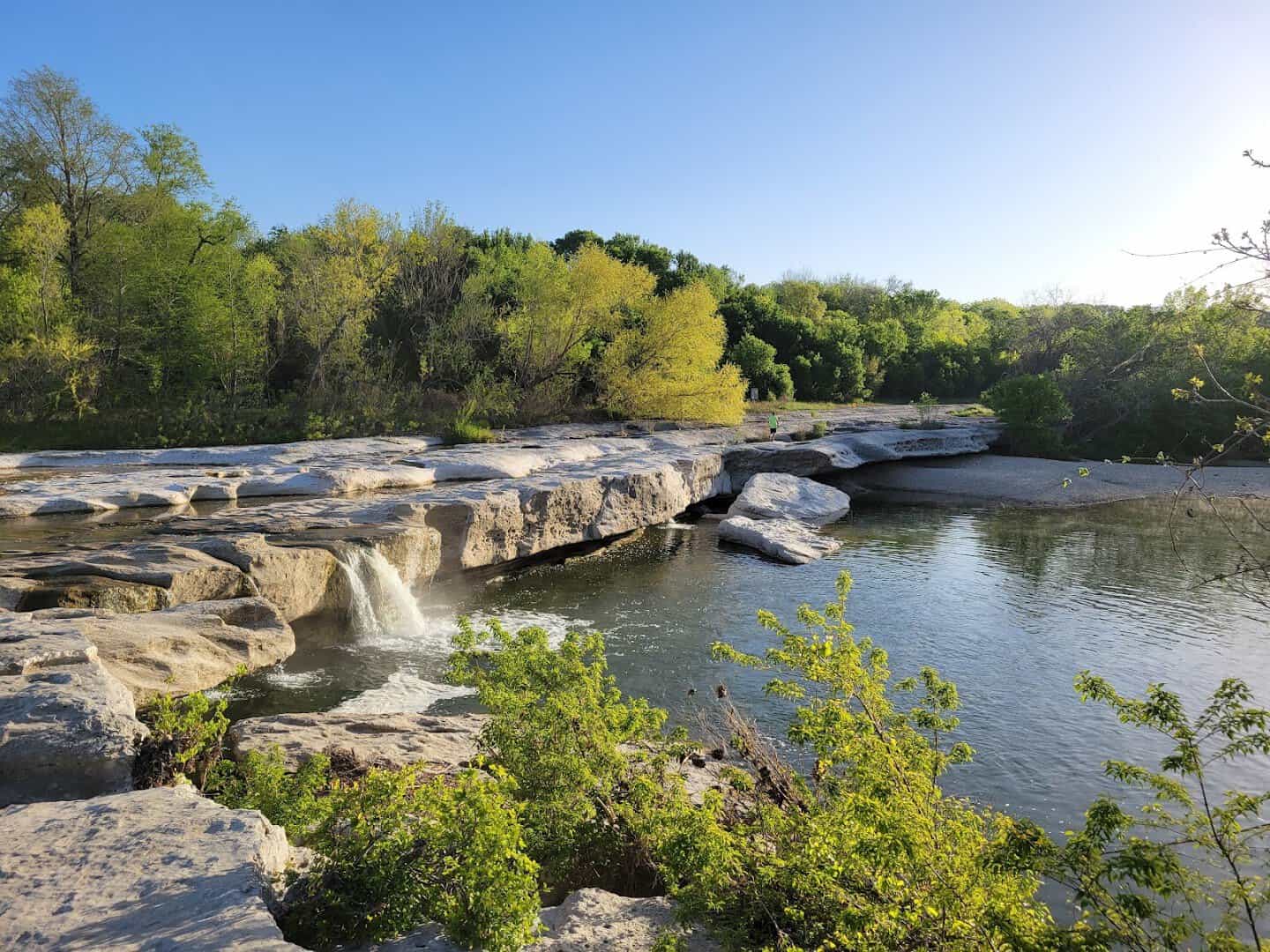 A waterfall spilling over limestone ledges at McKinney Falls State Park in Austin, Texas