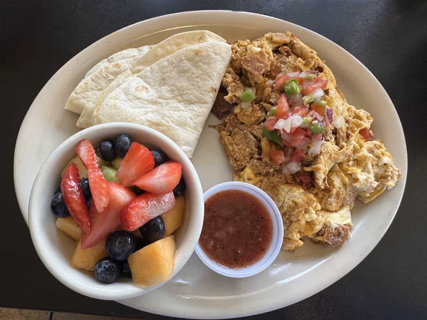 Migas breakfast plate with pico de gallo and fresh fruit at Jonathon's Diner in Dallas