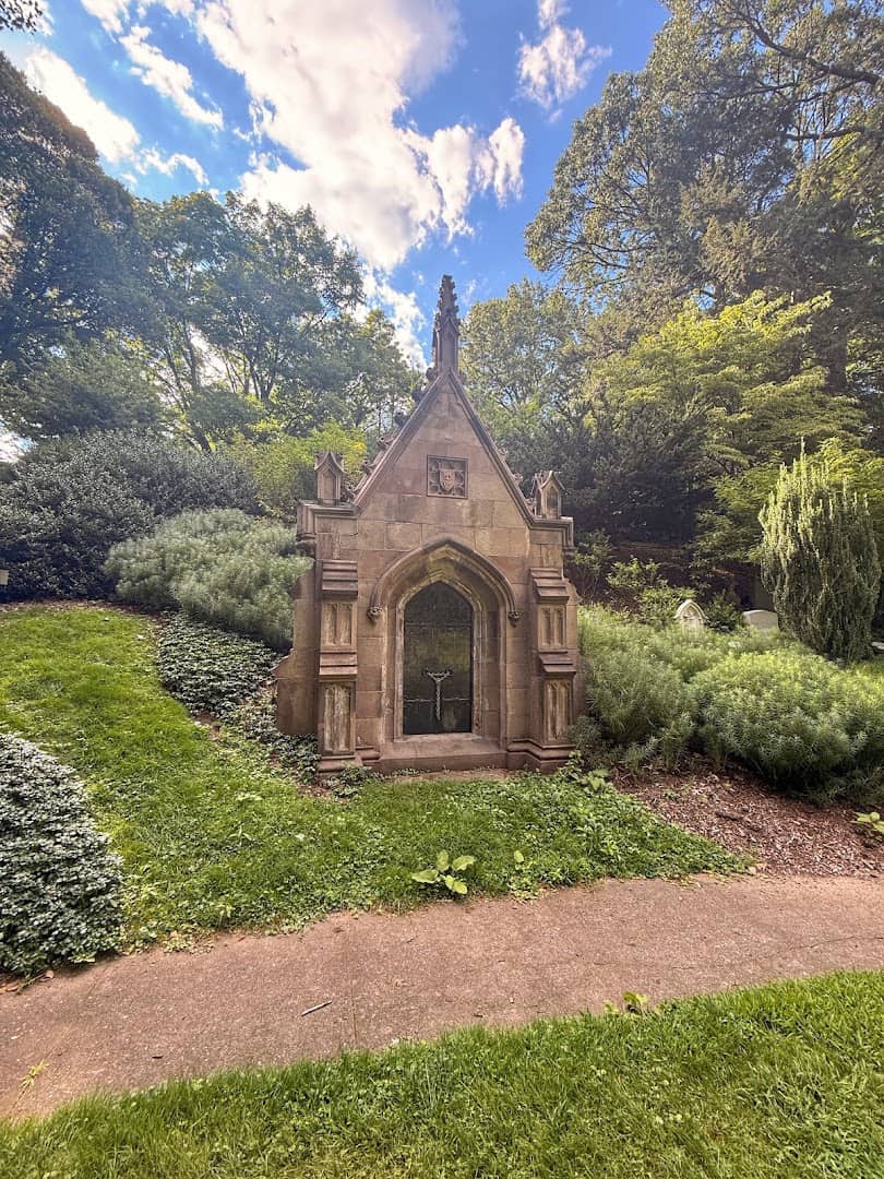 Stone Gothic mausoleum on a landscaped garden path at Mount Auburn Cemetery in Cambridge, Massachusetts
