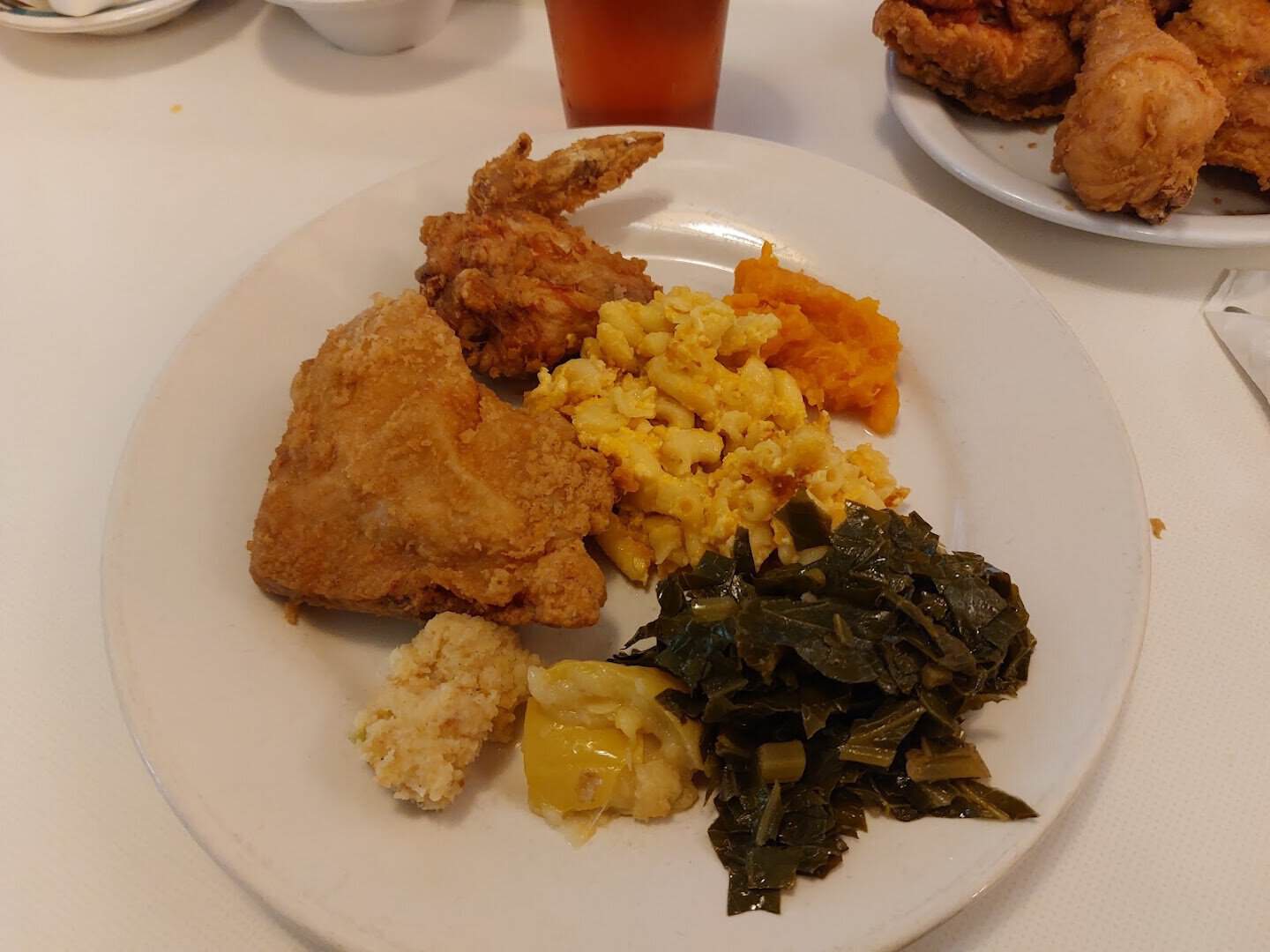 Plate of fried chicken with collard greens and mac and cheese at Mrs. Wilkes' Dining Room in Savannah, Georgia