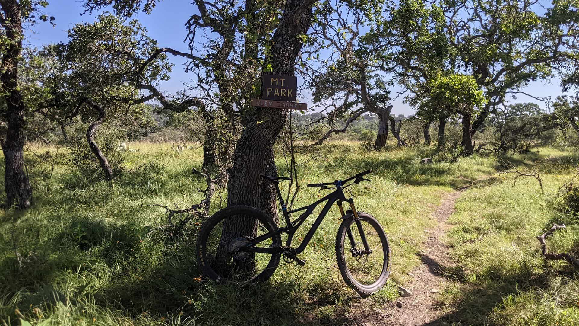 Mountain bike beside a singletrack trail winding through oaks at Flat Rock Ranch