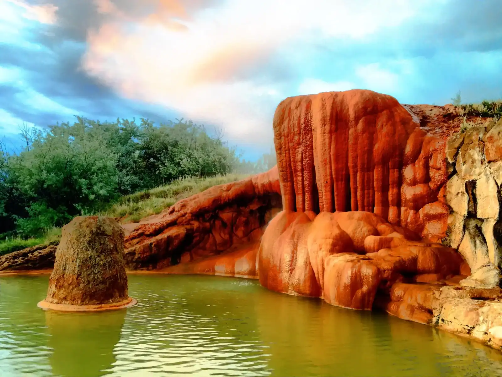 Orange travertine mound and spring-fed pool at Mystic Hot Springs in Monroe, Utah