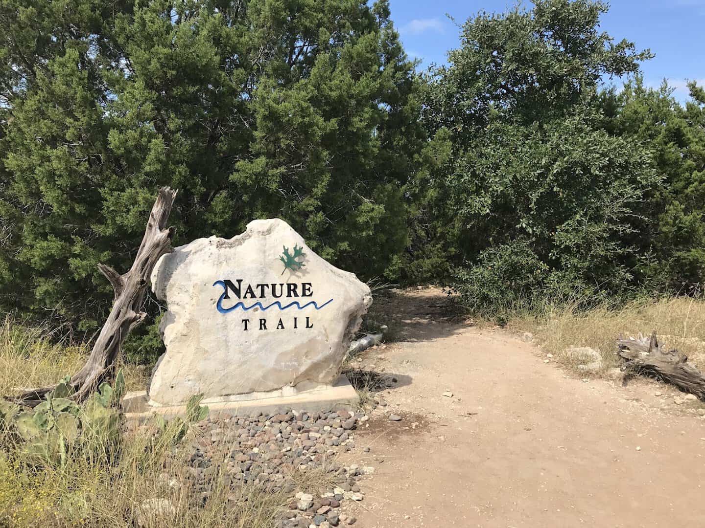Carved stone Nature Trail entrance sign at River Place Nature Trail in Austin, Texas
