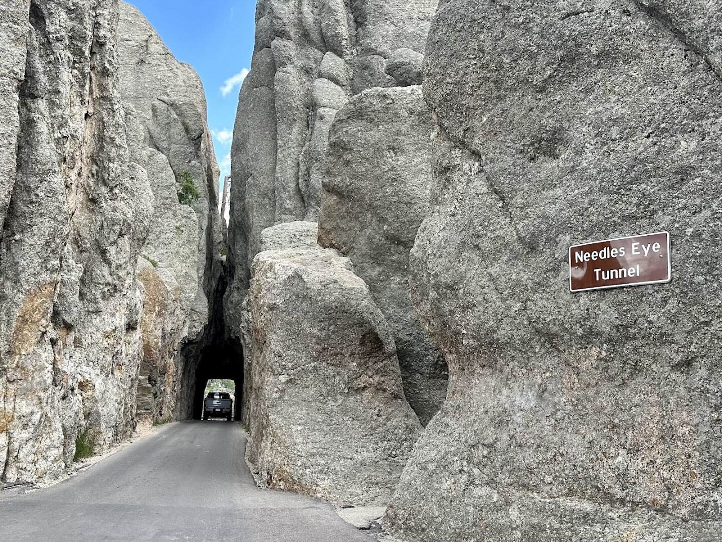 A car passing through the Needles Eye Tunnel among granite spires on the Needles Highway, South Dakota