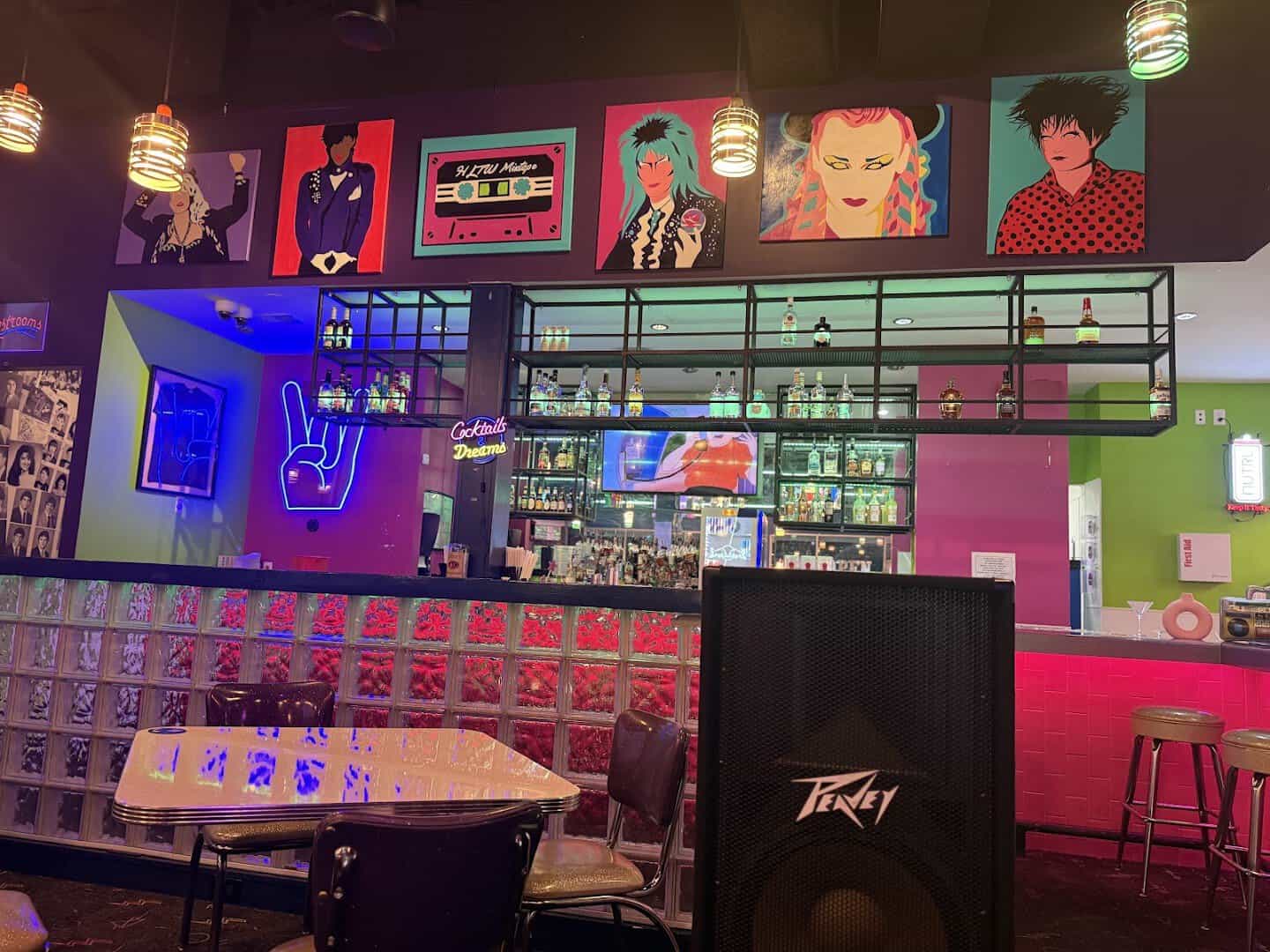 Neon portraits of 1980s music icons on the wall at Hungry Like The Wolf in Houston