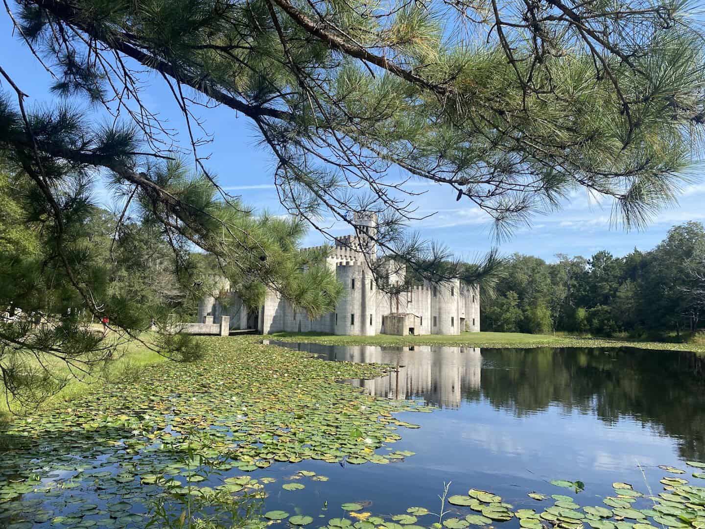 Stone medieval castle reflected across a pond at Newman's Castle near Bellville, Texas