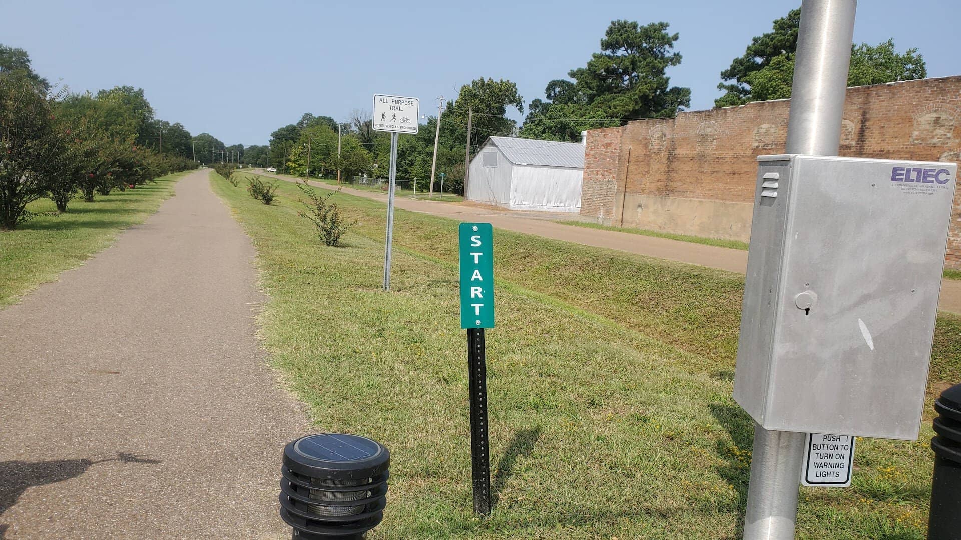 Paved Northeast Texas Trail with a start mile marker entering town