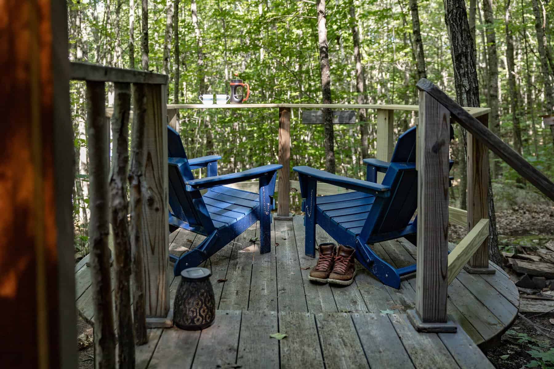 Wooden deck with chairs in the forest at Nurture Through Nature, Denmark, Maine