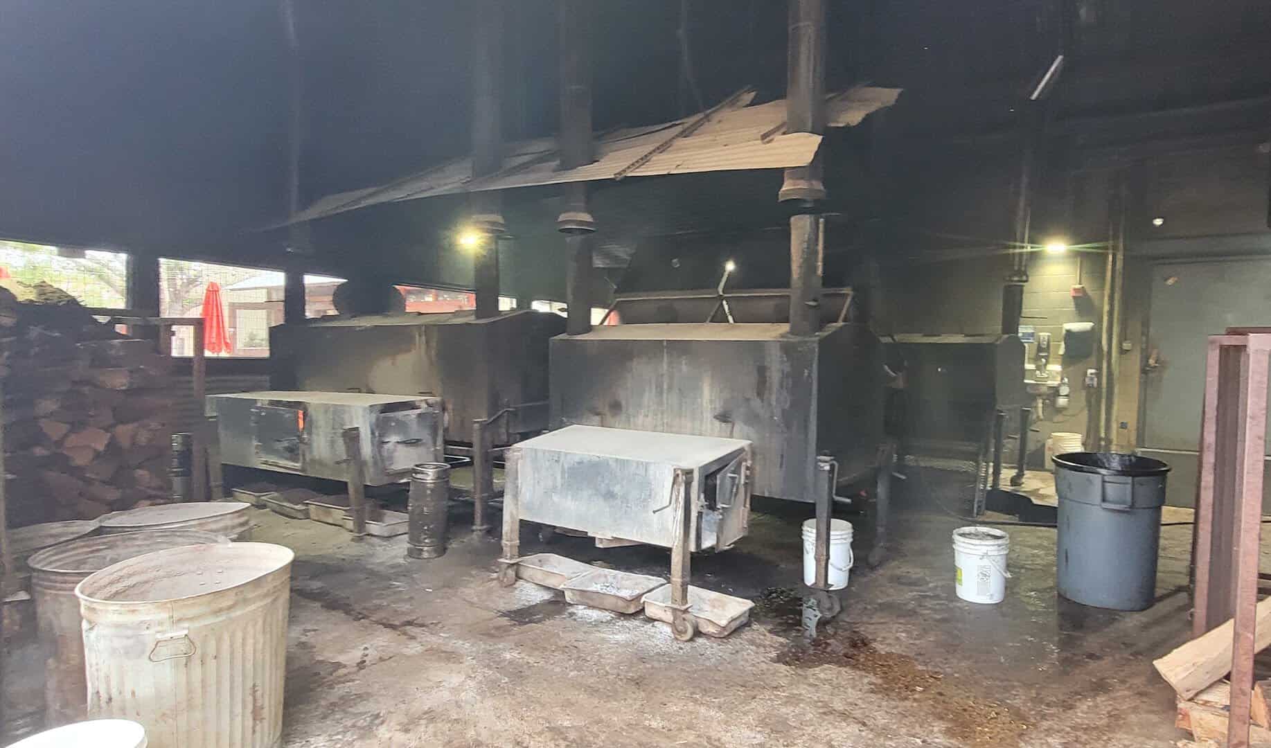 The offset steel pits and stacked firewood in the pit room at Pecan Lodge in Dallas