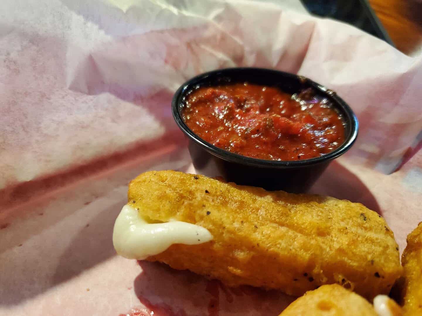 A mozzarella stick with marinara at Old School Pizza Tavern in Arlington, Texas