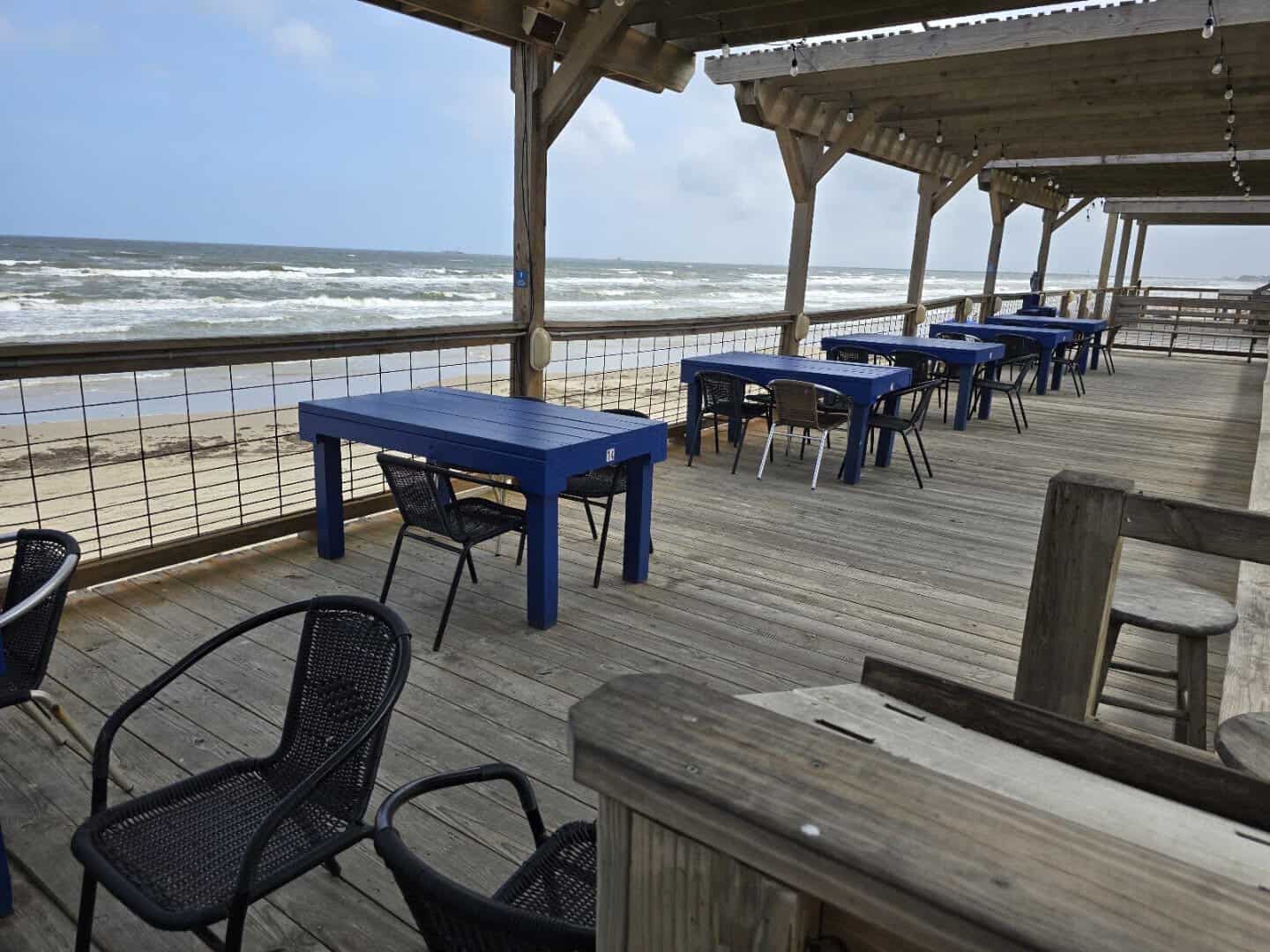Blue tables on the open deck at Seahorse Bar and Grill in Surfside Beach, Texas