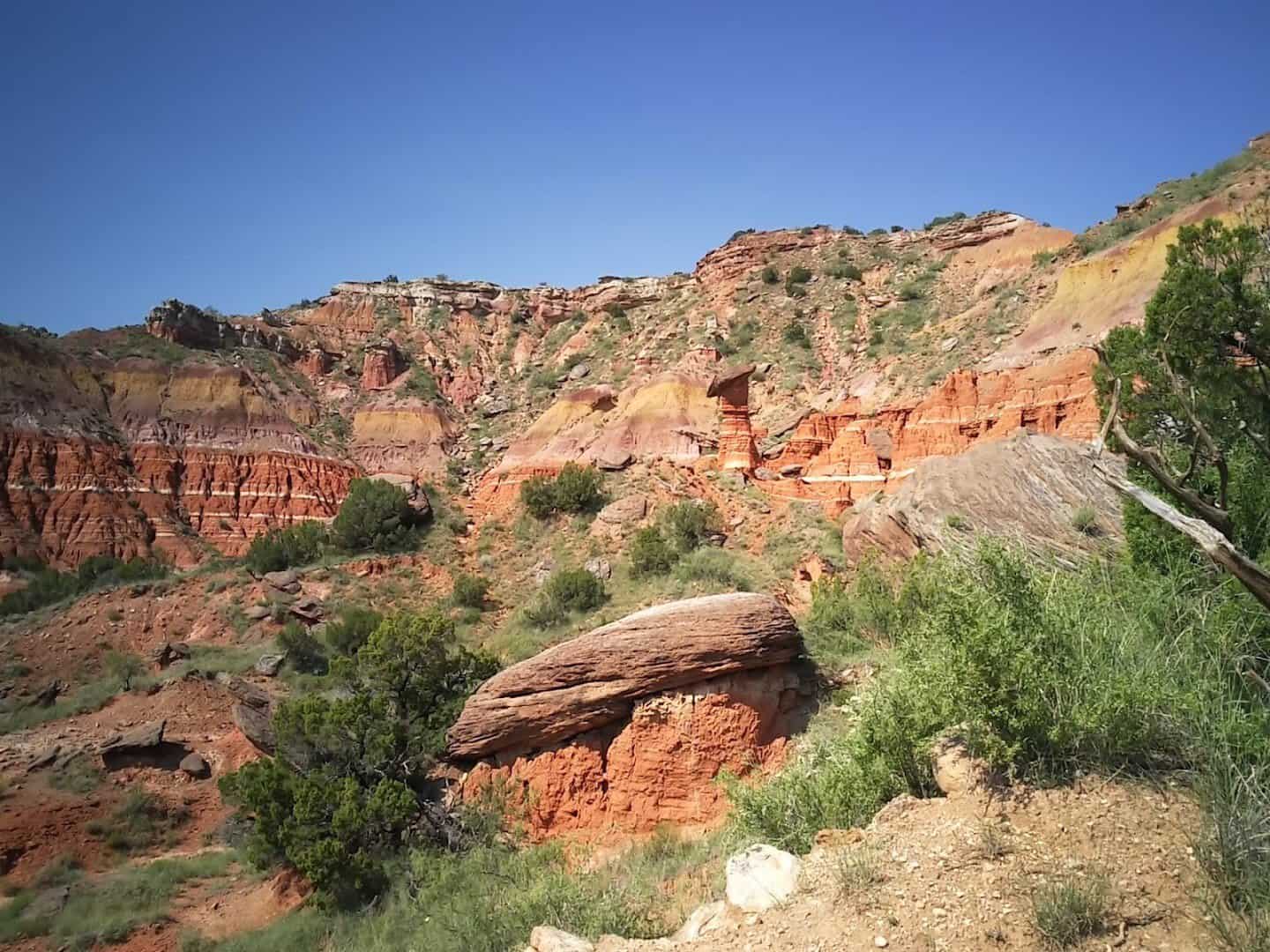 Spring greenery below the banded red and orange canyon walls at Palo Duro Canyon State Park in the Texas Panhandle
