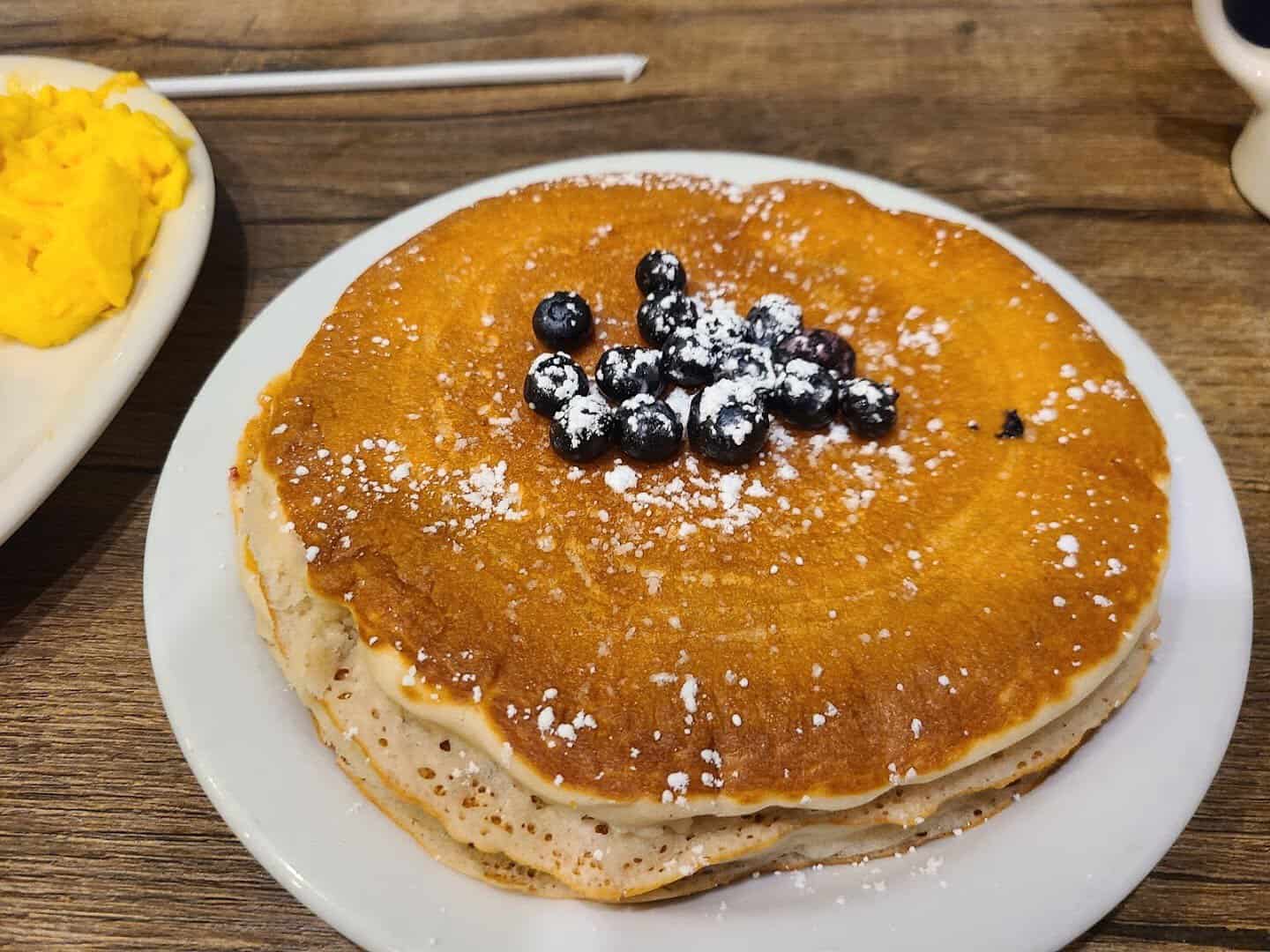 A tall stack of pancakes topped with blueberries at Bobbie's Southern Kitchen