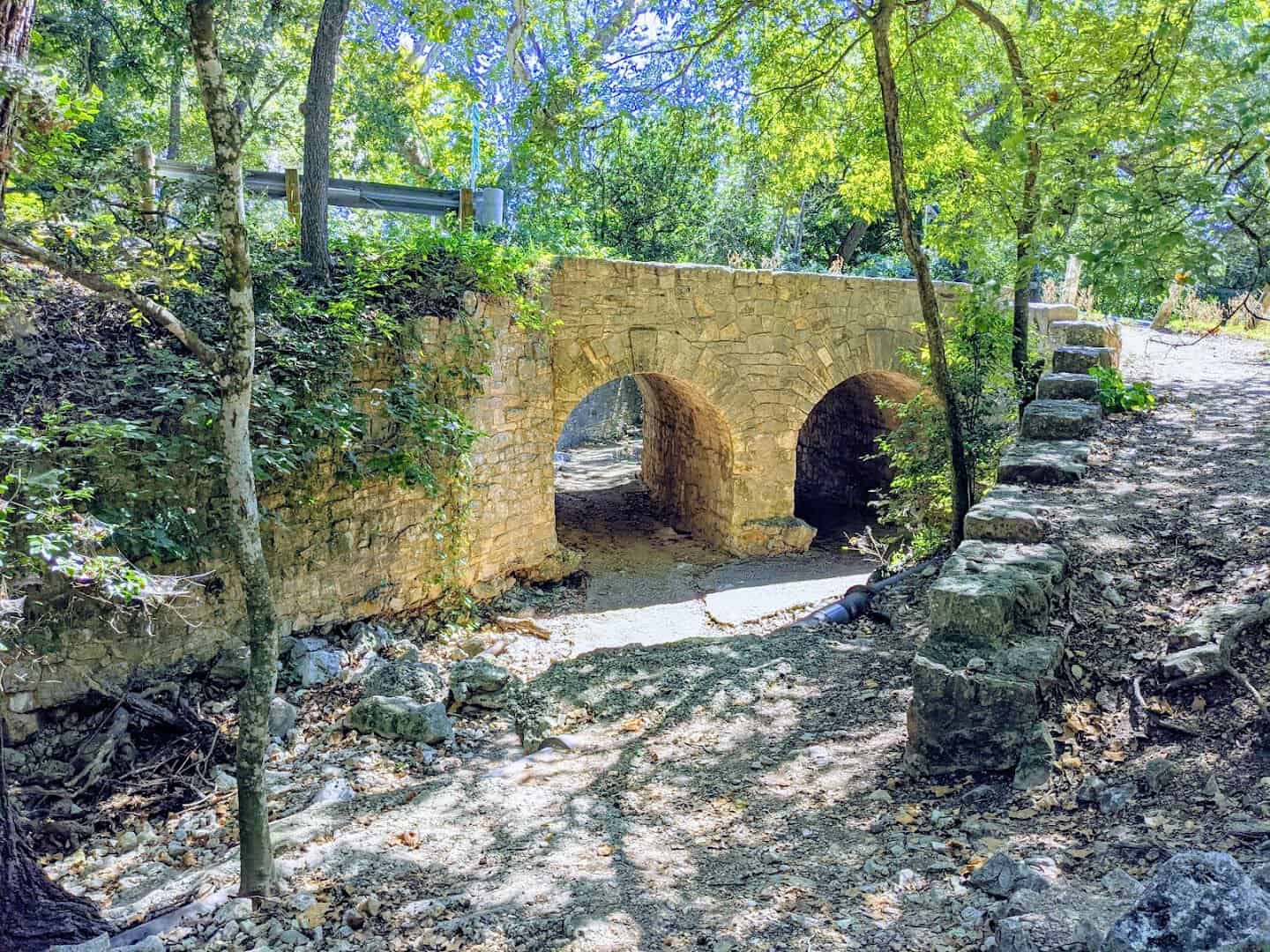 Old stone arch bridge over the dry creek bed in Panther Canyon at Landa Park, New Braunfels