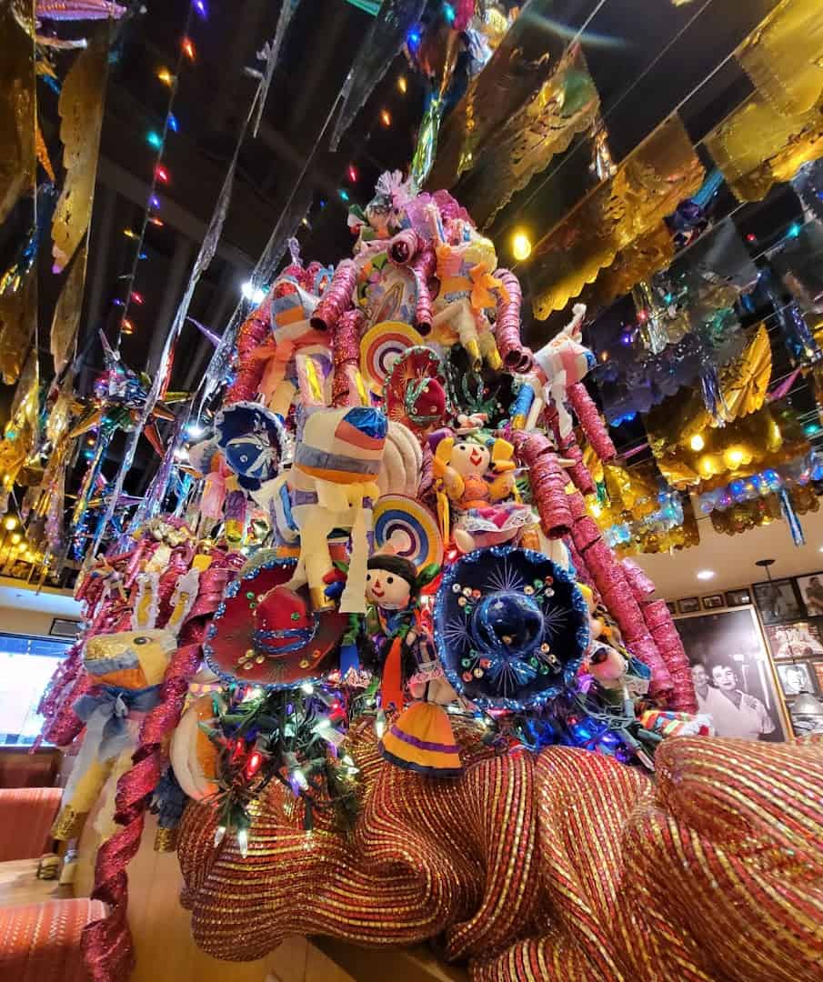 Colorful papel picado and a pinata-covered Christmas tree at Mi Familia at the Rim in San Antonio