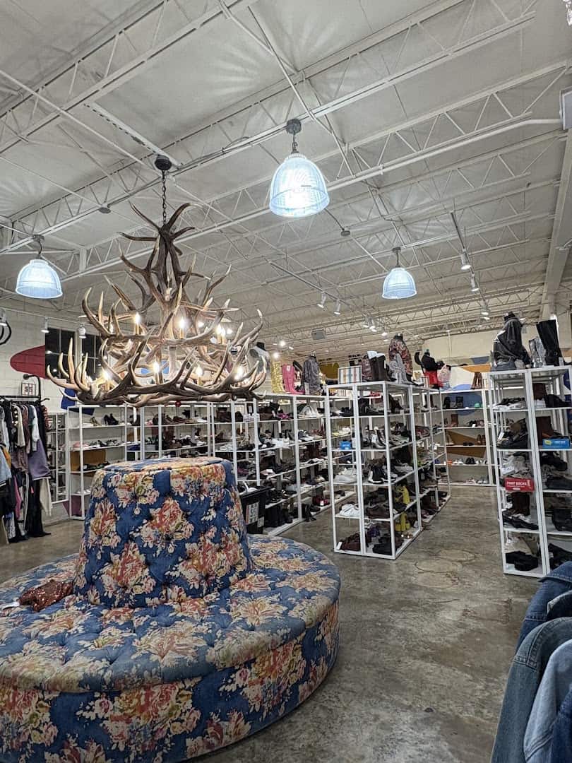 Curated clothing racks and chandelier inside Pavement resale shop in Austin