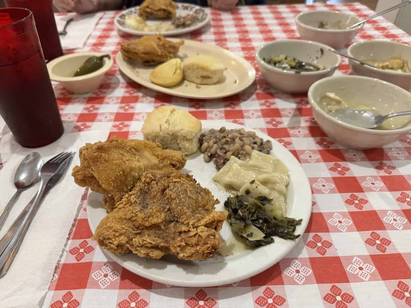 Family-style table of fried chicken and sides at Pickett House Restaurant in Woodville, Texas