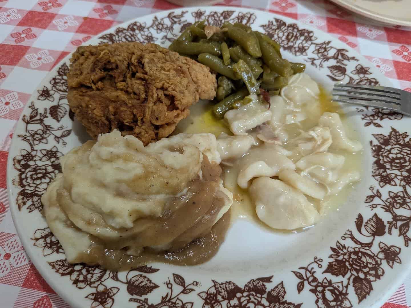 Plate of fried chicken, dumplings and sides at Pickett House Restaurant in Woodville, Texas