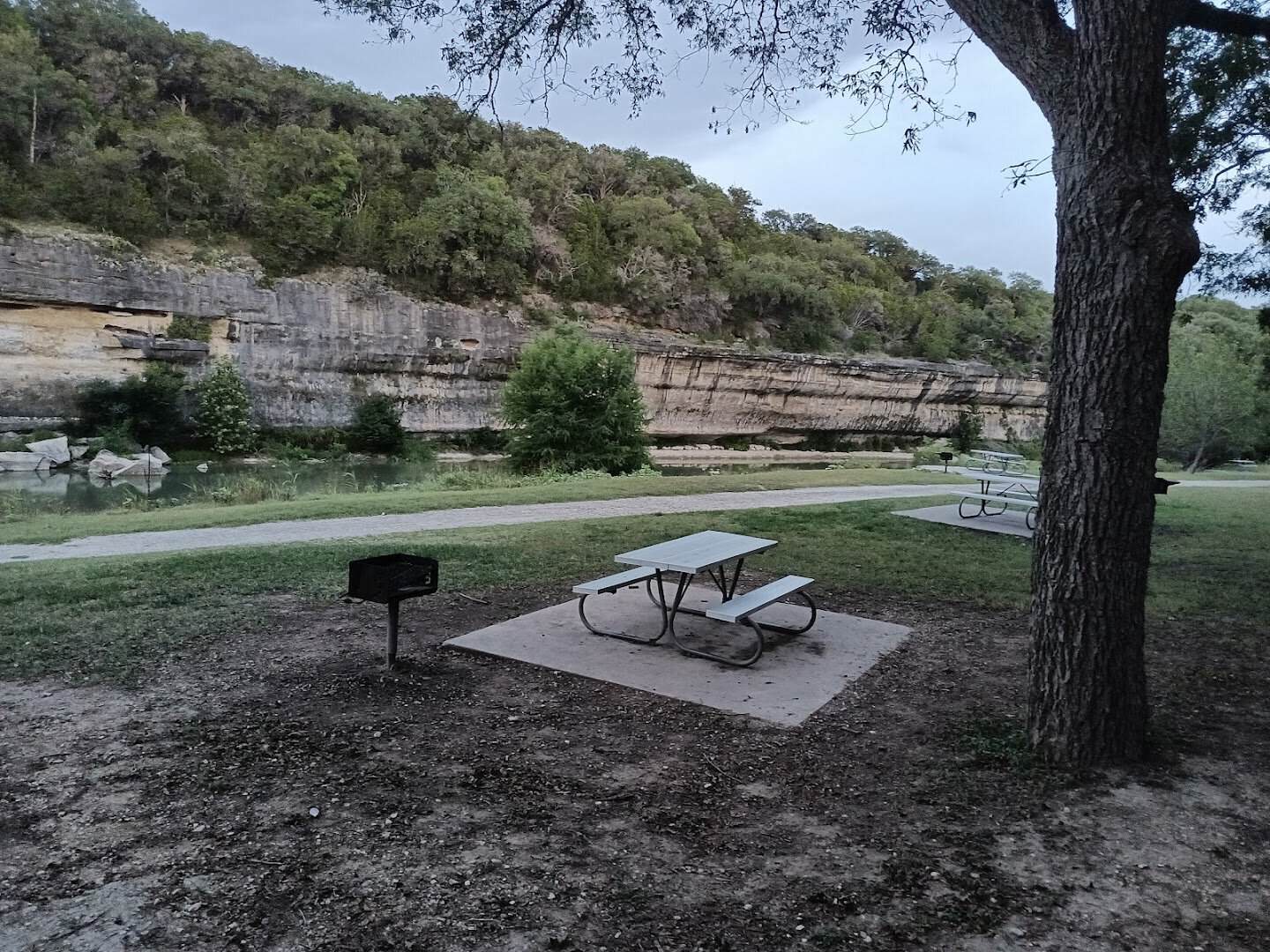 Picnic table campsite beneath a limestone bluff at Guadalupe River State Park