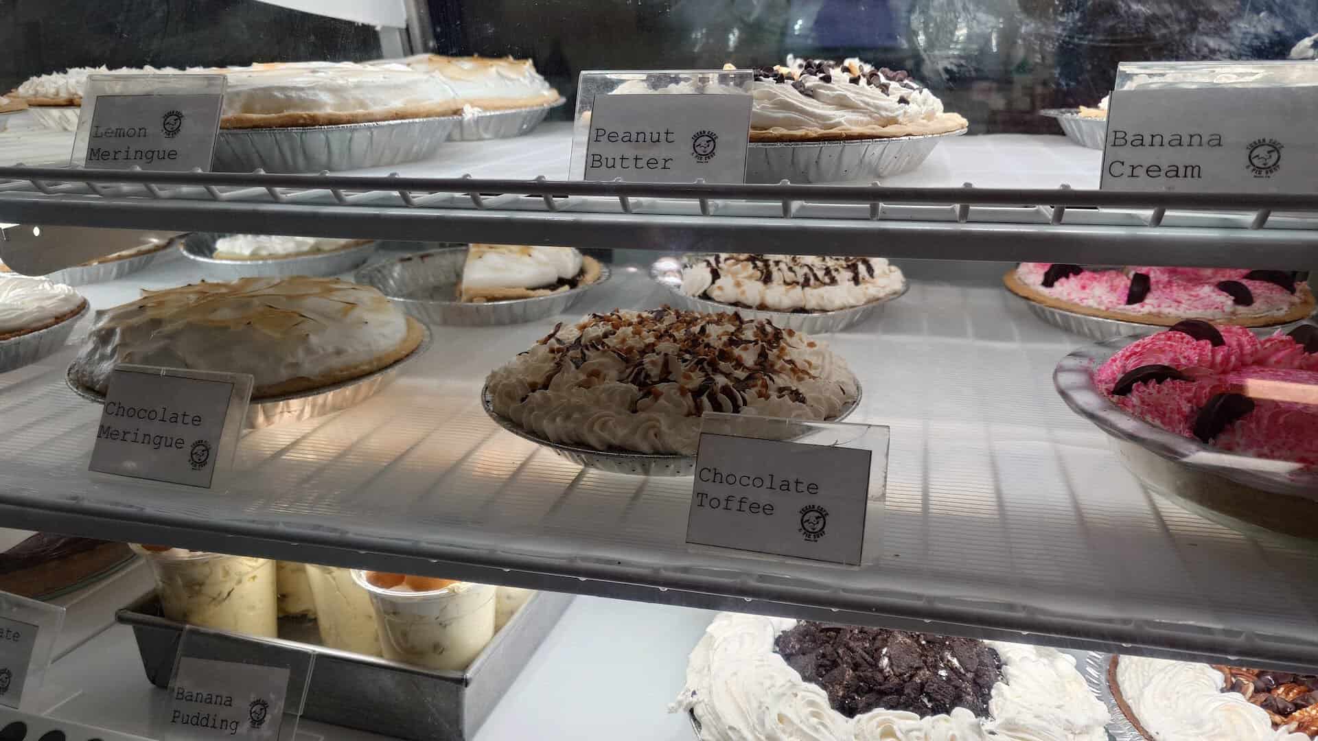 Counter of labeled cream pies including banana cream at Texan Cafe and Pie Shop in Hutto, Texas