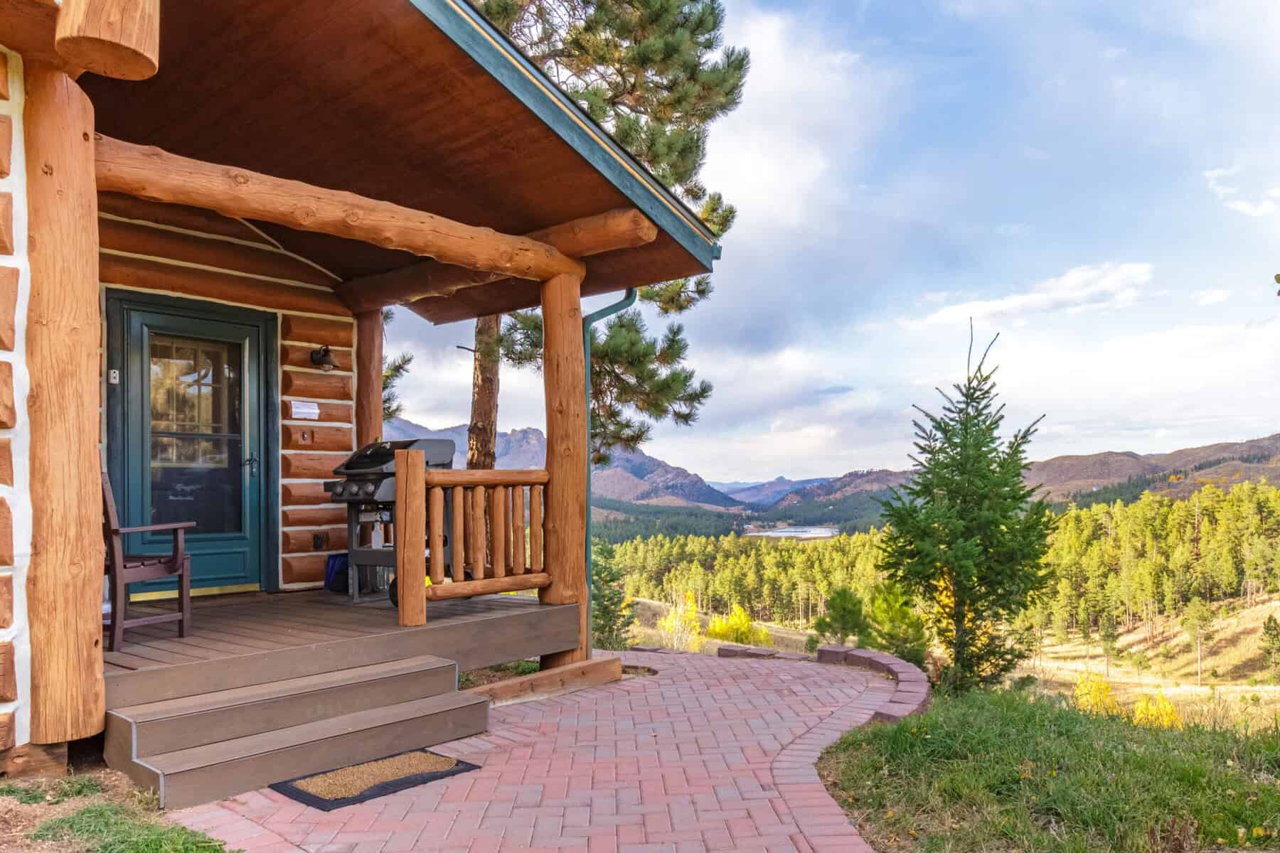 Log cabin porch opening to a mountain view at Pikes Peak Ranch in Woodland Park, Colorado