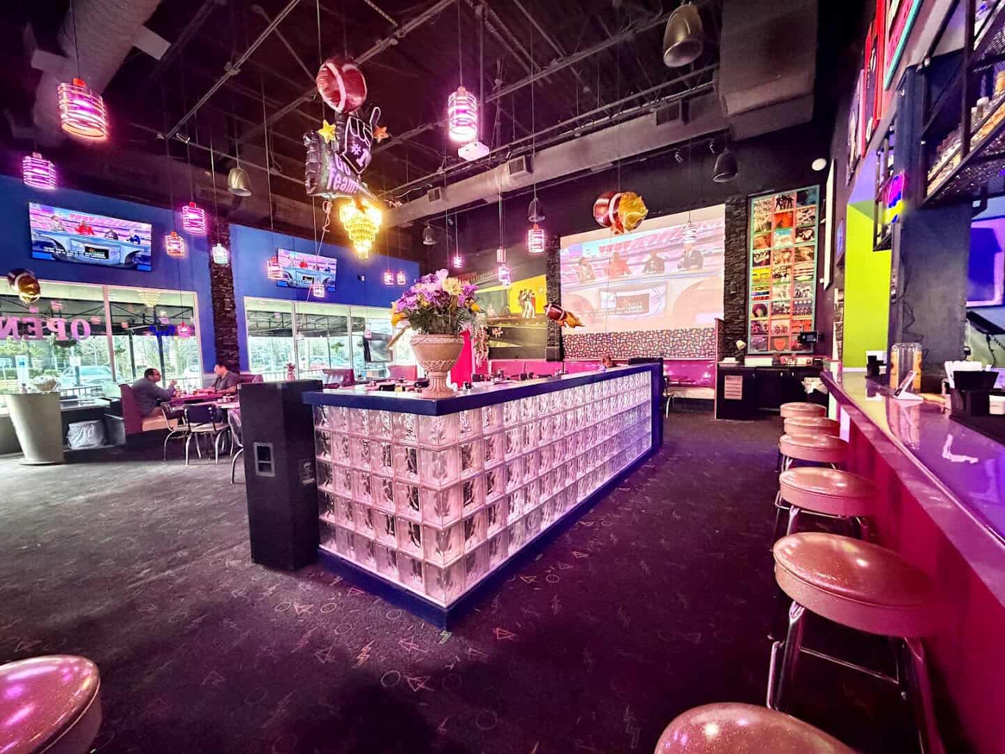 Pink vinyl bar stools and neon at Hungry Like The Wolf in Houston